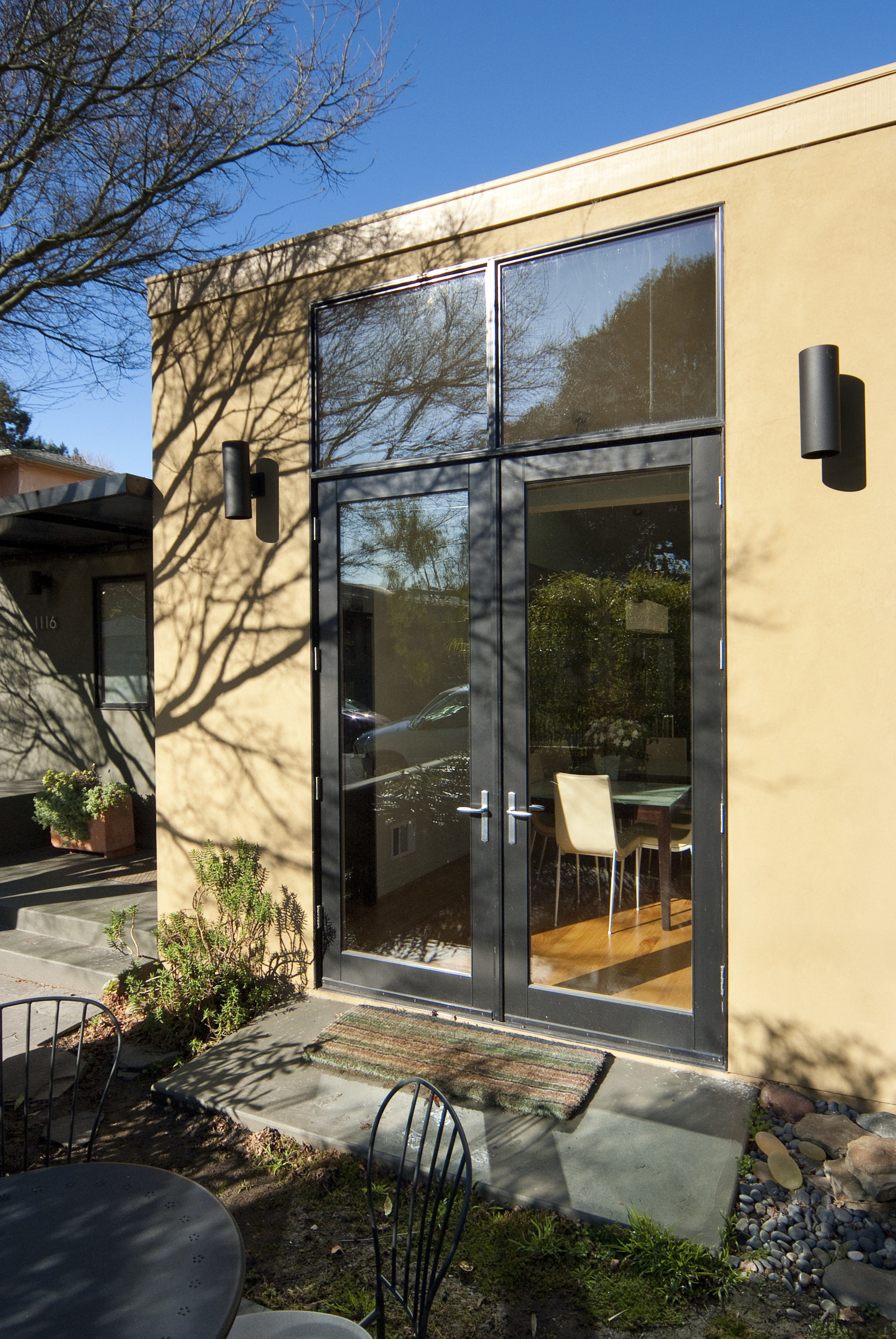 Outdoor patio area with furniture. - Outdoor patio architecture, cottage, courtyard, door, facade, home, house, outdoor structure, real estate, shed, siding, window, black