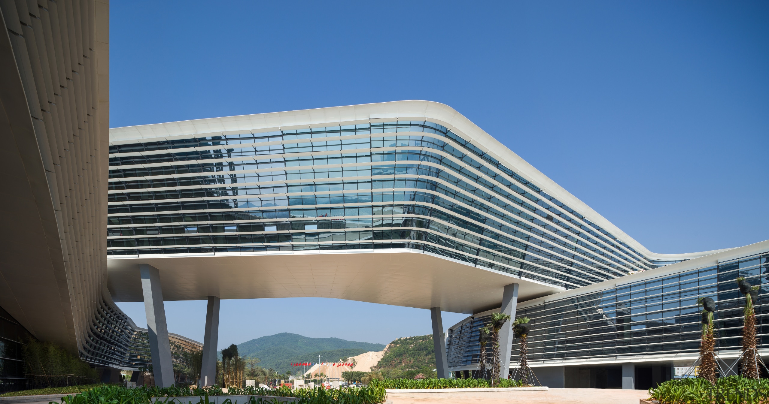 A ribbon of offices wraps the Zhuhai International architecture, building, commercial building, condominium, convention center, corporate headquarters, daylighting, daytime, facade, headquarters, metropolitan area, mixed use, sky, teal