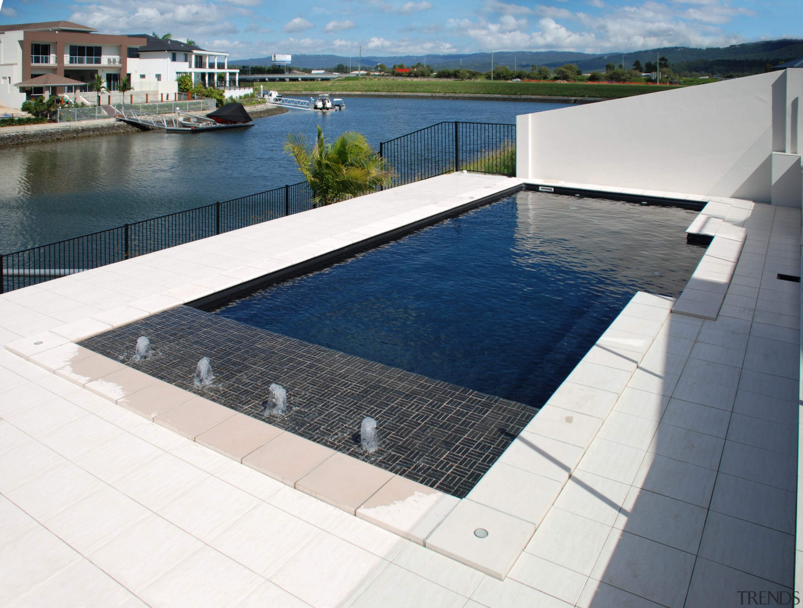 View of the pool &amp; water features - composite material, condominium, daylighting, floor, flooring, leisure, property, real estate, swimming pool, water, white