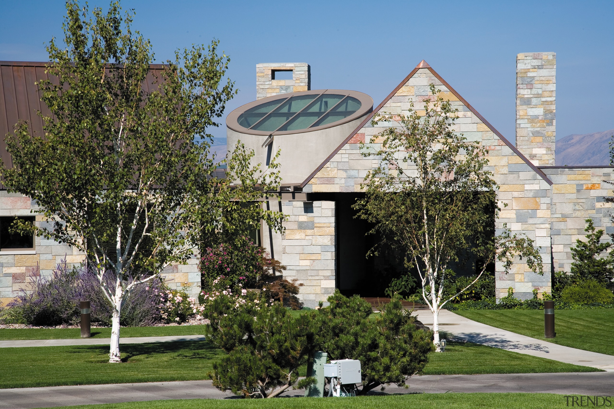 An exterior view of the entrance way to architecture, building, campus, corporate headquarters, daytime, facade, home, house, plant, property, real estate, residential area, tree, brown