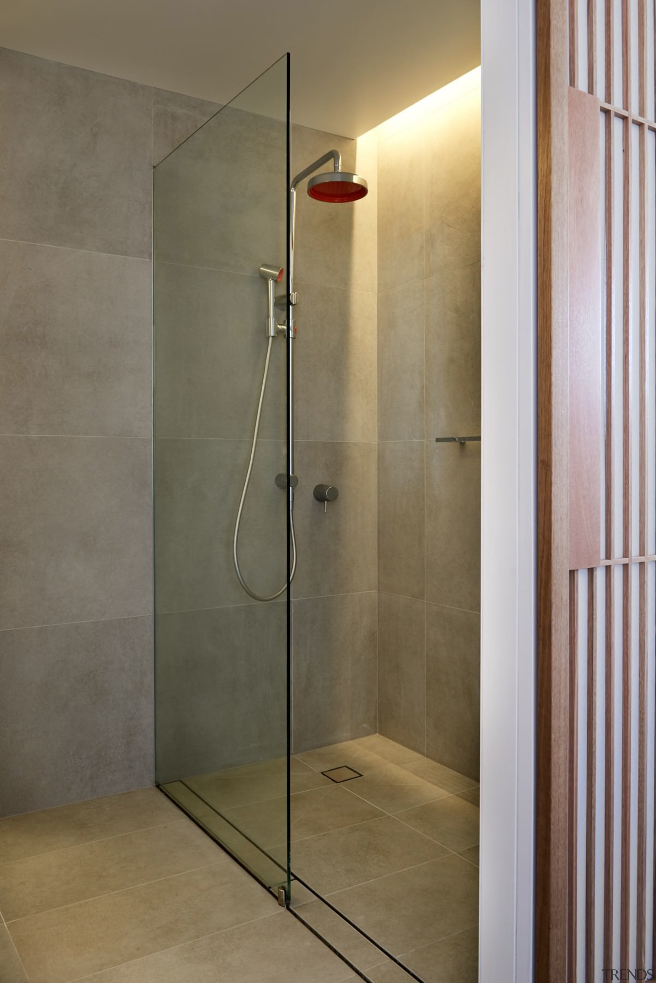 The bathroom has tiles running into the shower angle, bathroom, floor, glass, plumbing fixture, shower, shower door, tile, wall, gray, brown