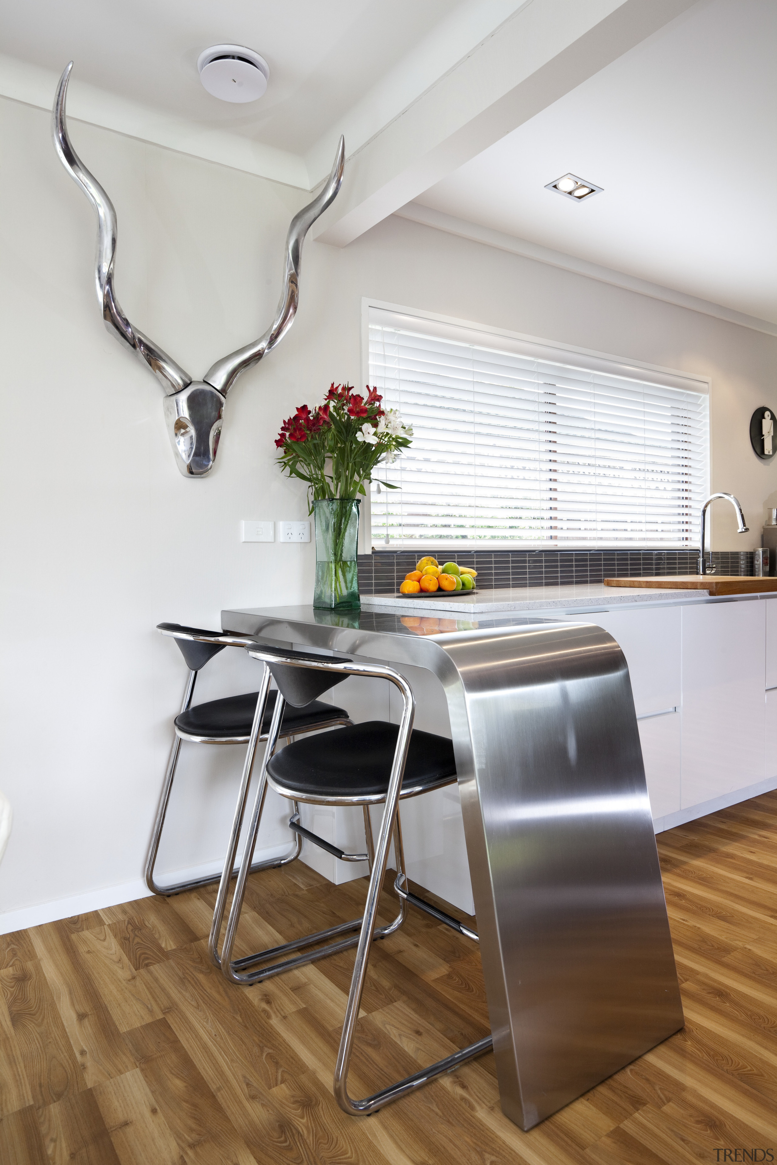 A handcrafted stainless steel breakfast bar creates a chair, countertop, floor, flooring, furniture, interior design, kitchen, loft, product design, room, table, gray, white