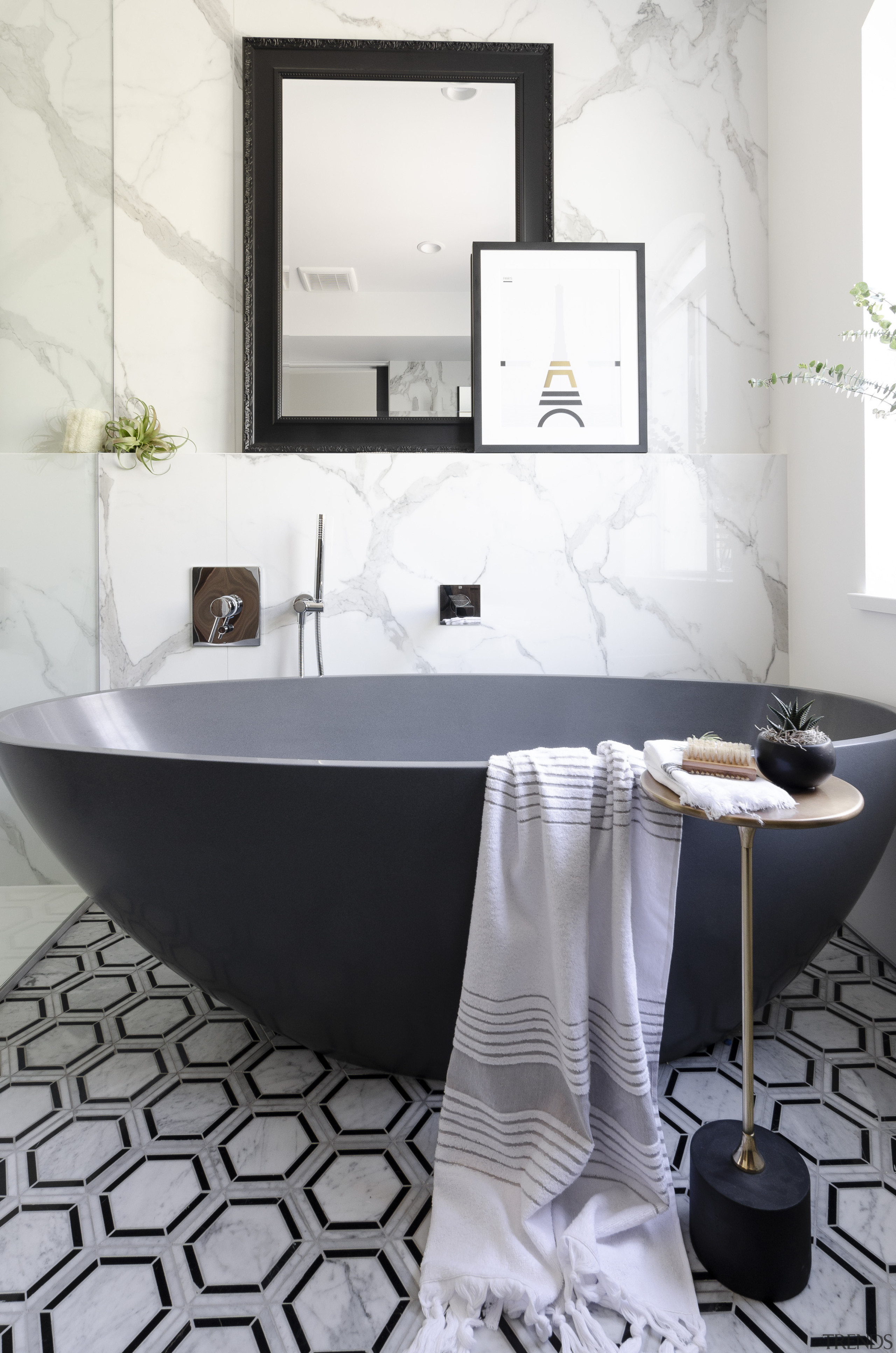 A honed bluestone freestanding tub adds a modern 