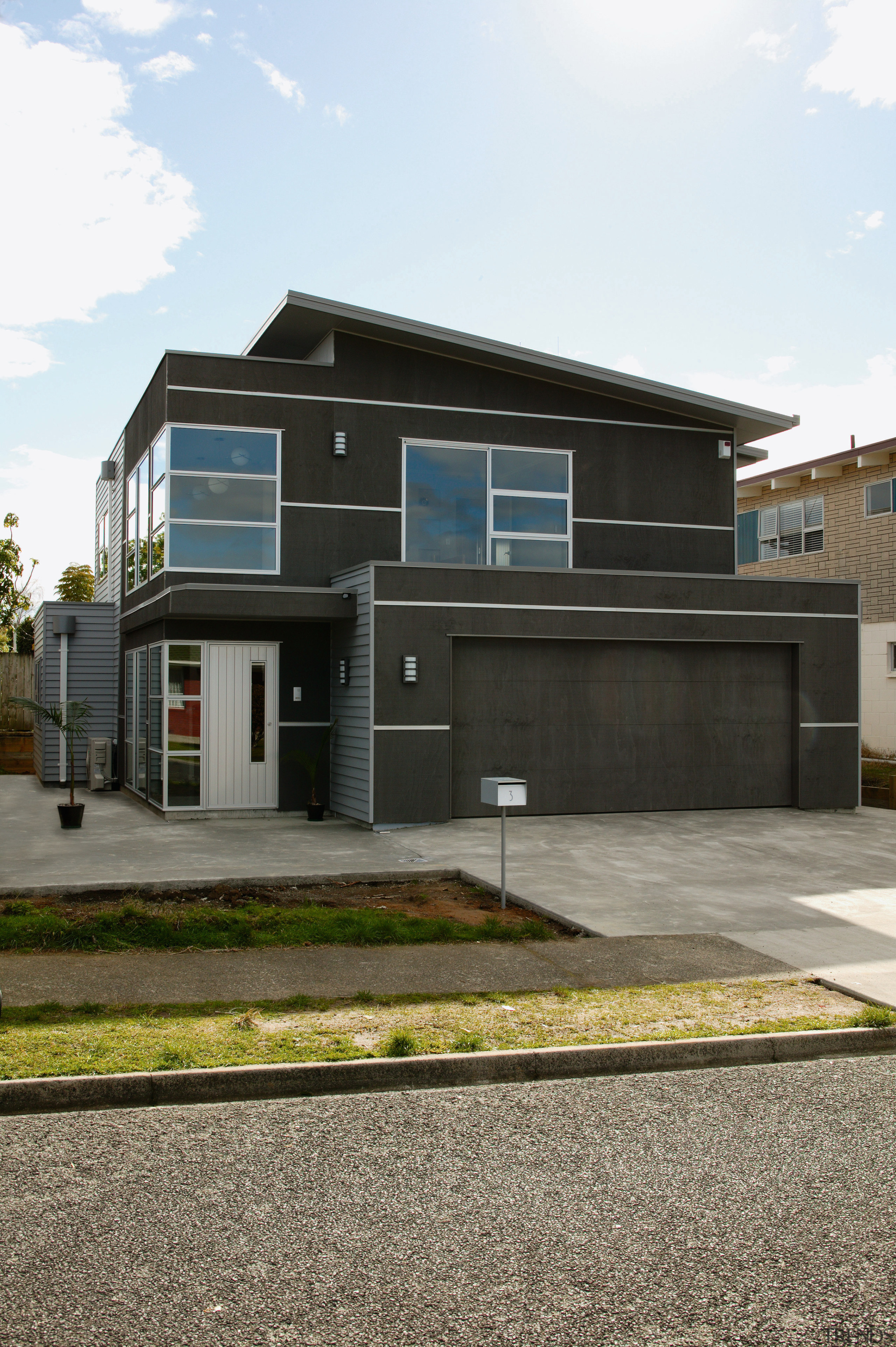 view of this home featuring the clean lines architecture, asphalt, building, elevation, facade, home, house, luxury vehicle, property, real estate, residential area, white, black