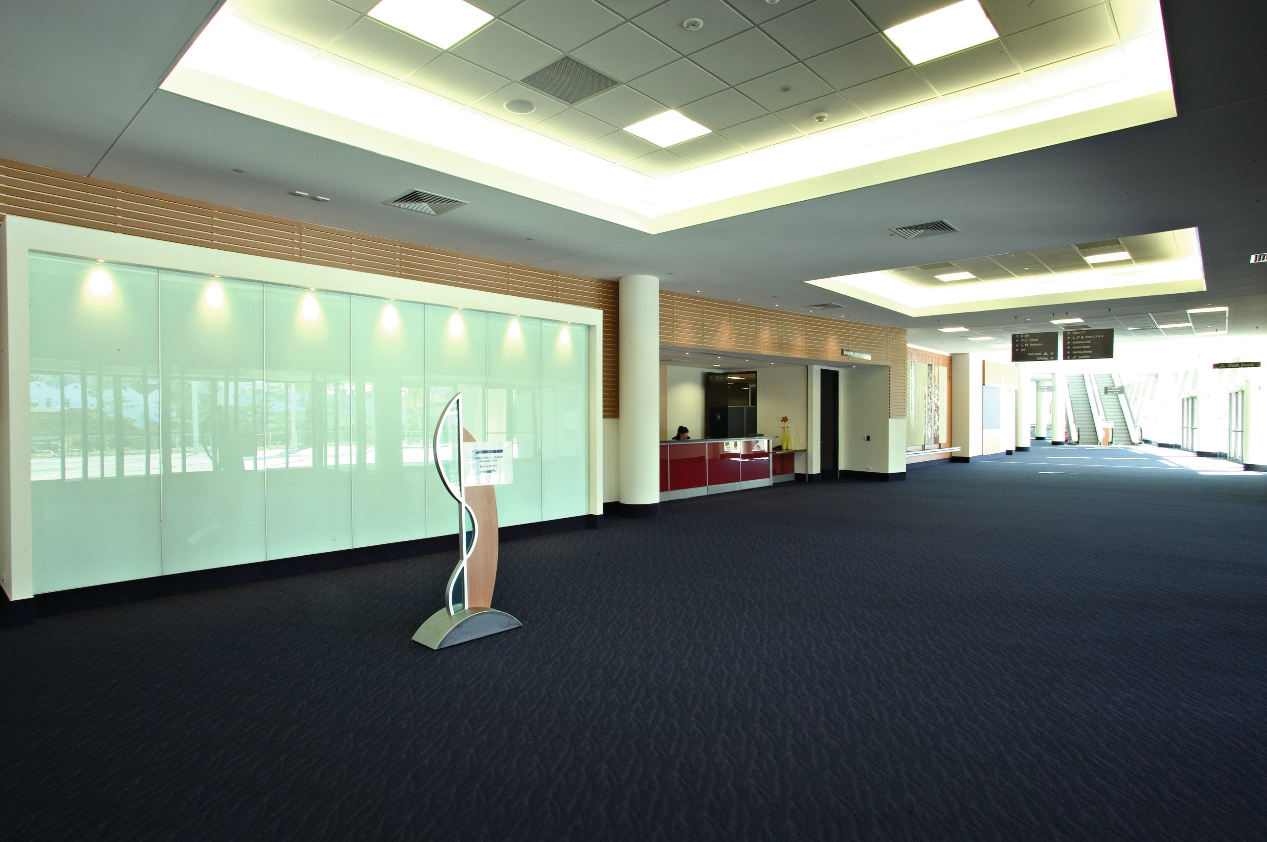 Large accessway in building with information desk, escalators ceiling, floor, flooring, interior design, leisure centre, real estate, window, black