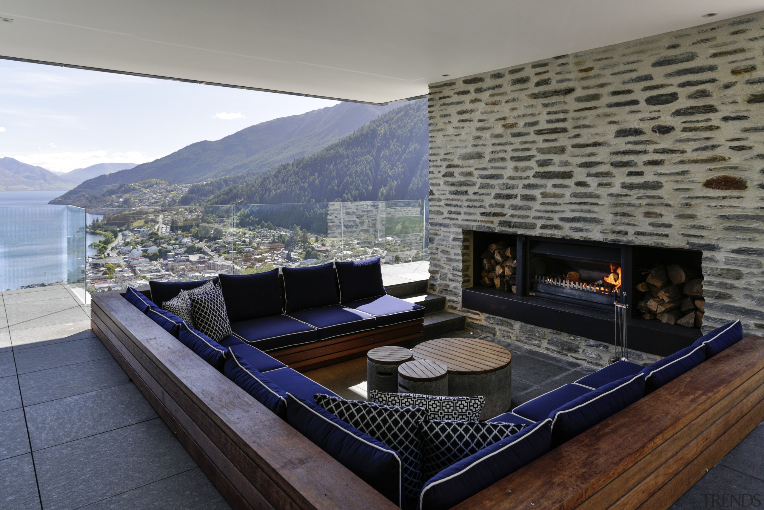 This outdoor room in a hillside house by architecture, fireplace, hearth, home, house, interior design, living room, penthouse apartment, property, real estate, gray