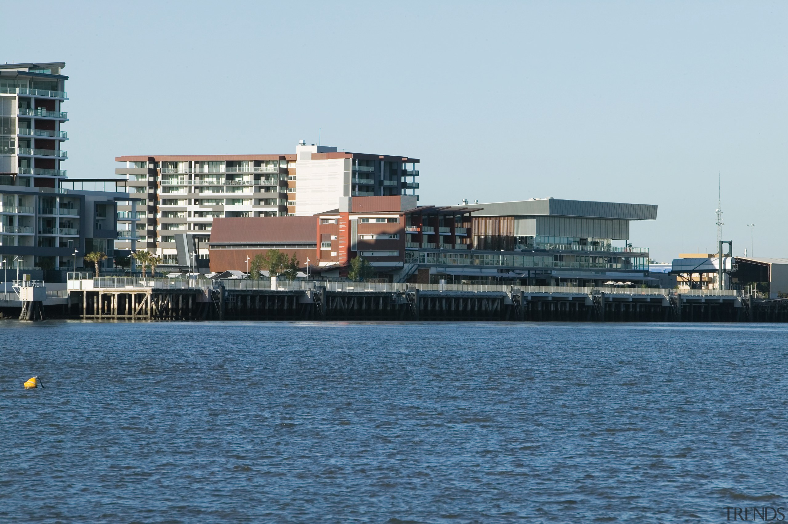 An exterior view of the Portside Wharf Apartment building, channel, city, condominium, port, sea, ship, sky, urban area, water, water transportation, waterway, white, teal