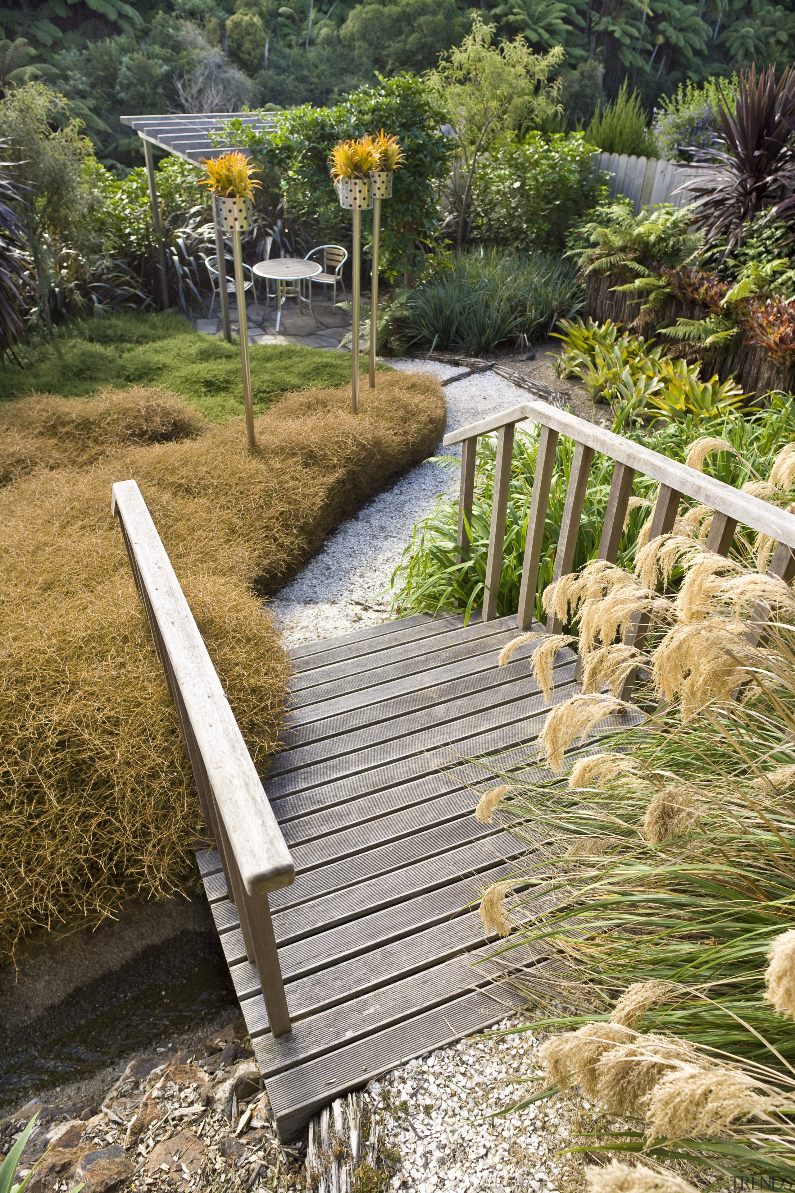 View of a landscaped garden which features a garden, grass, grass family, landscape, outdoor structure, path, plant, walkway, wood, brown