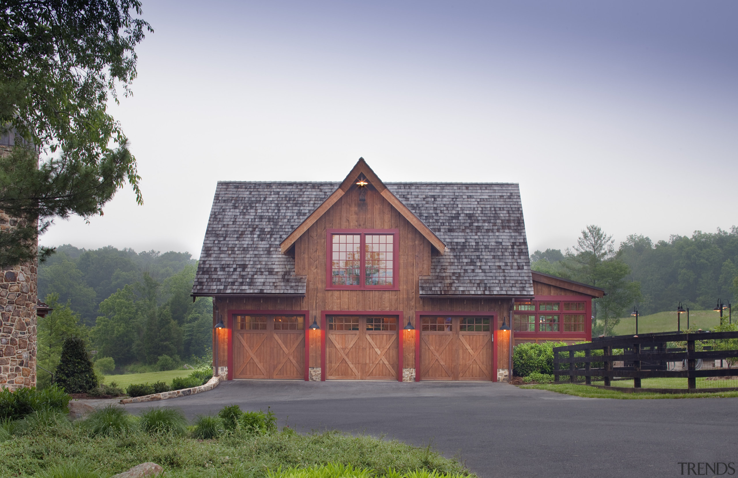 View of wooden home with three garages. - barn, building, cottage, estate, facade, farm, farmhouse, home, house, property, real estate, roof, rural area, shed, sky, tree, white