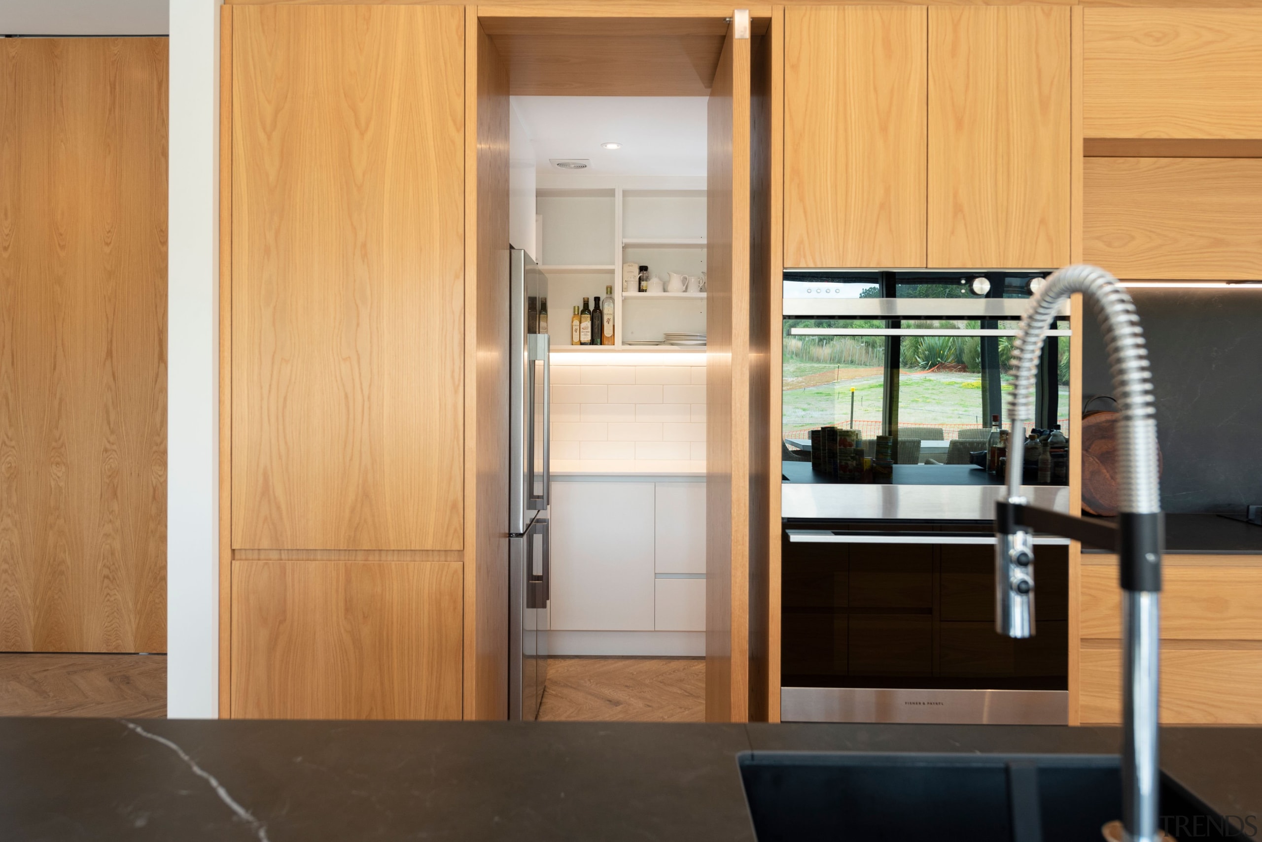 A sleek pivot door in the wood cabinetry 