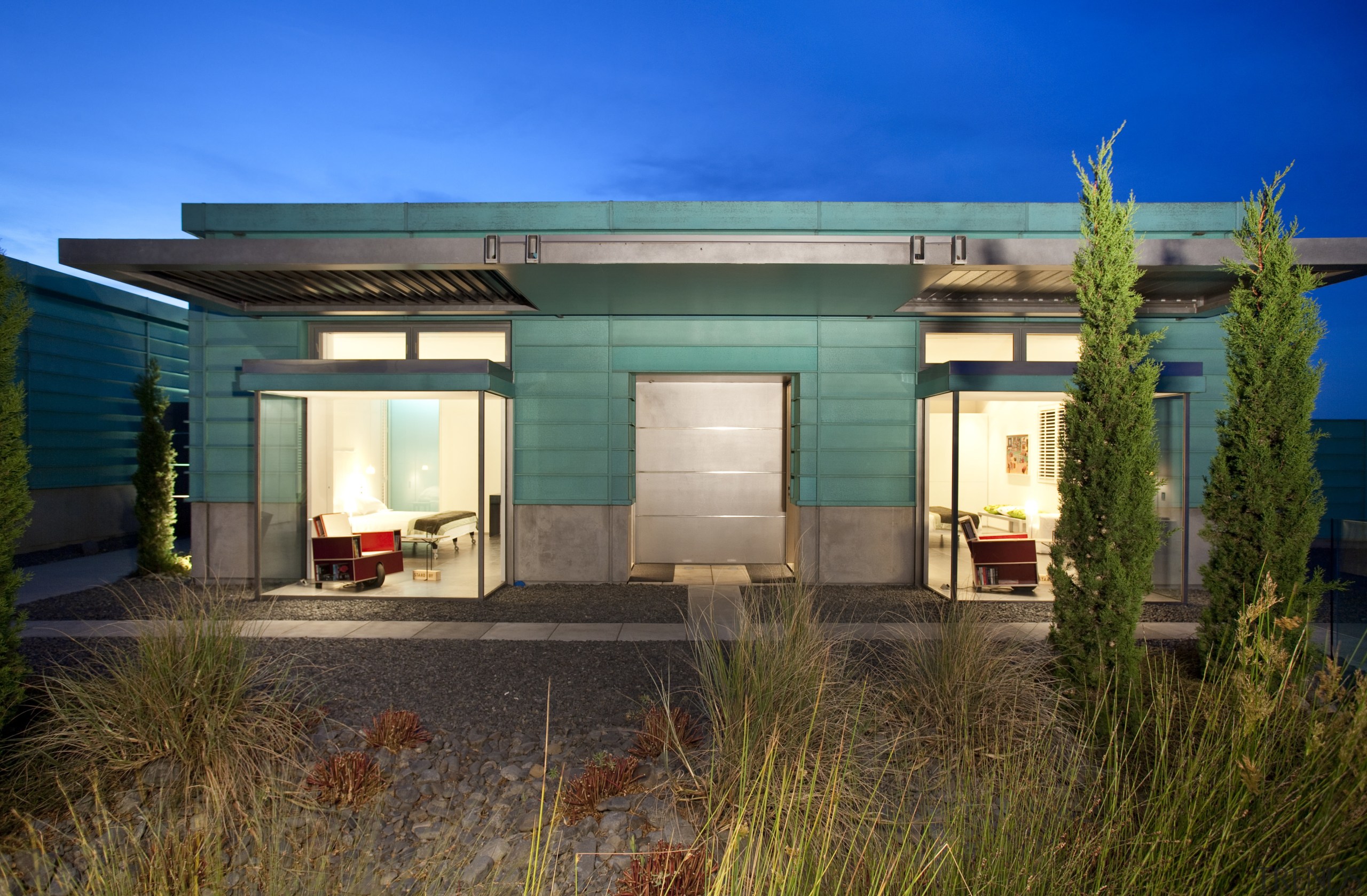 Exterior shot of building with lights on and architecture, cottage, estate, facade, home, house, property, real estate, roof, sky, brown