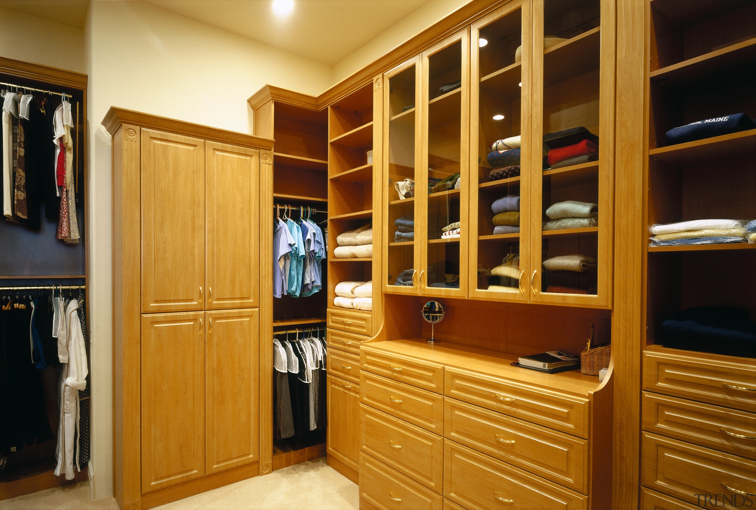 A view of a walk in wardrobe made bookcase, cabinetry, closet, furniture, room, shelving, wardrobe, orange, brown