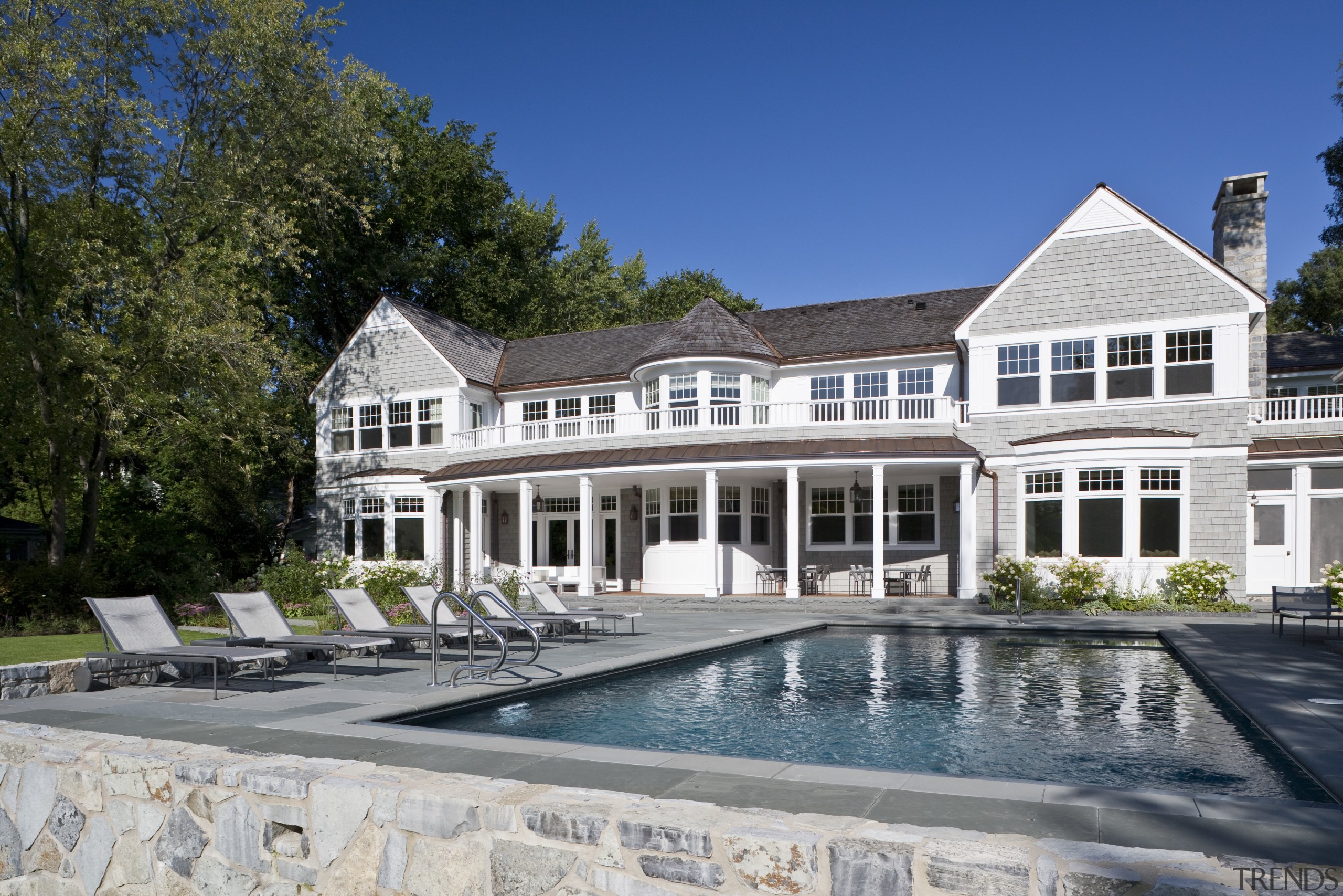 View of the homes exterior featuring stained cider building, cottage, estate, facade, home, house, mansion, property, real estate, residential area, swimming pool, villa, window, gray