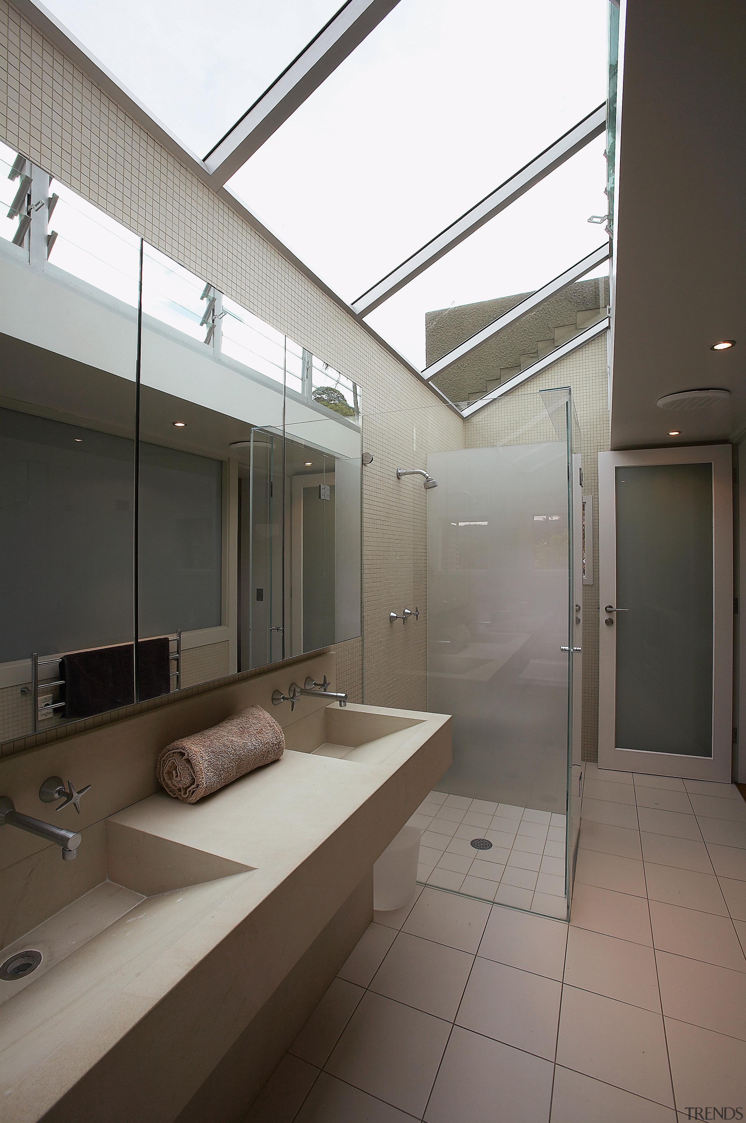 A view of the bathrom featuring tiled walls/flooring, architecture, bathroom, daylighting, floor, glass, house, interior design, real estate, window, gray, black