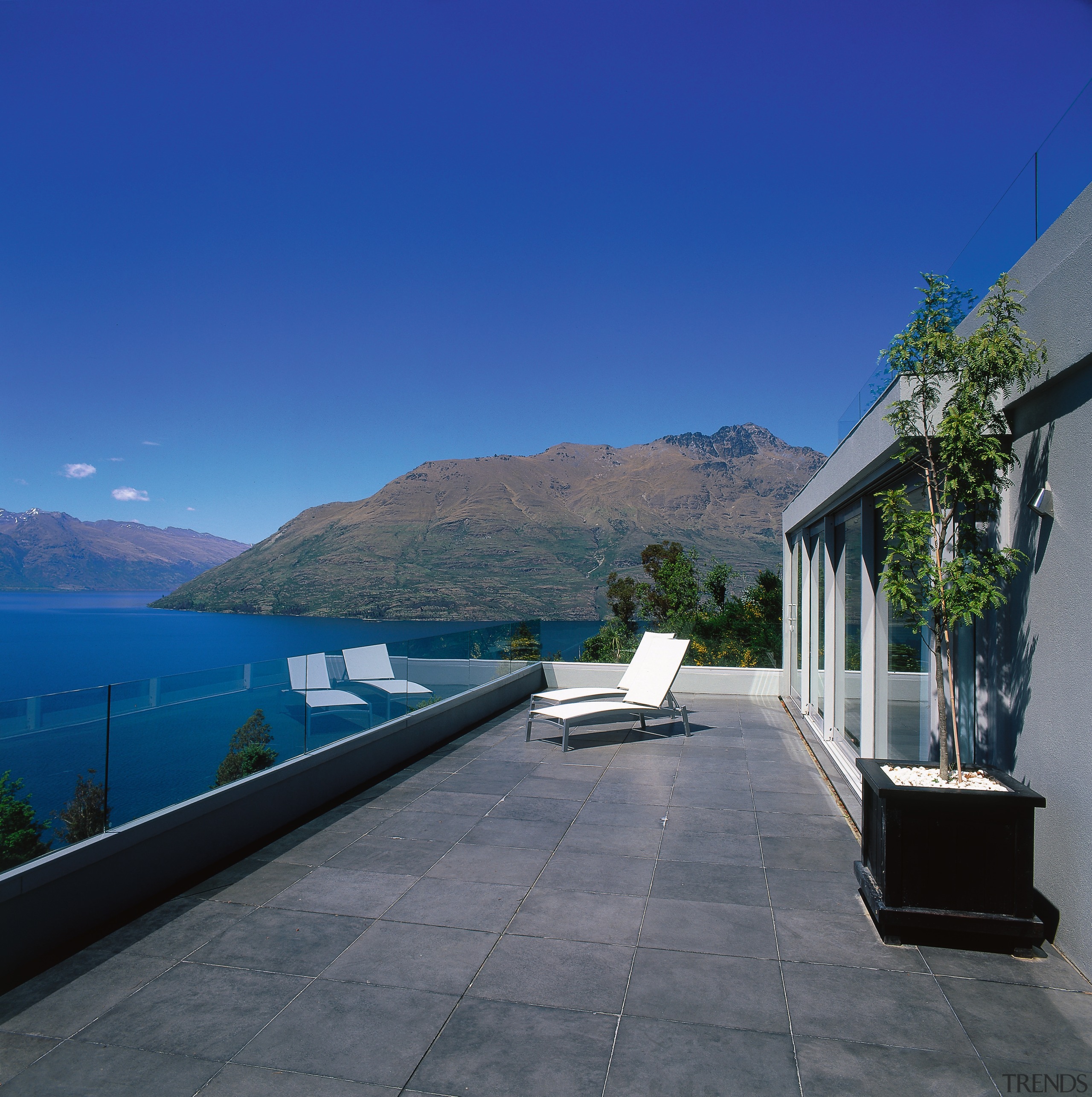 An exterior view of the patio area, concrete apartment, architecture, estate, home, house, mountain, property, real estate, roof, sky, villa, water, blue, gray