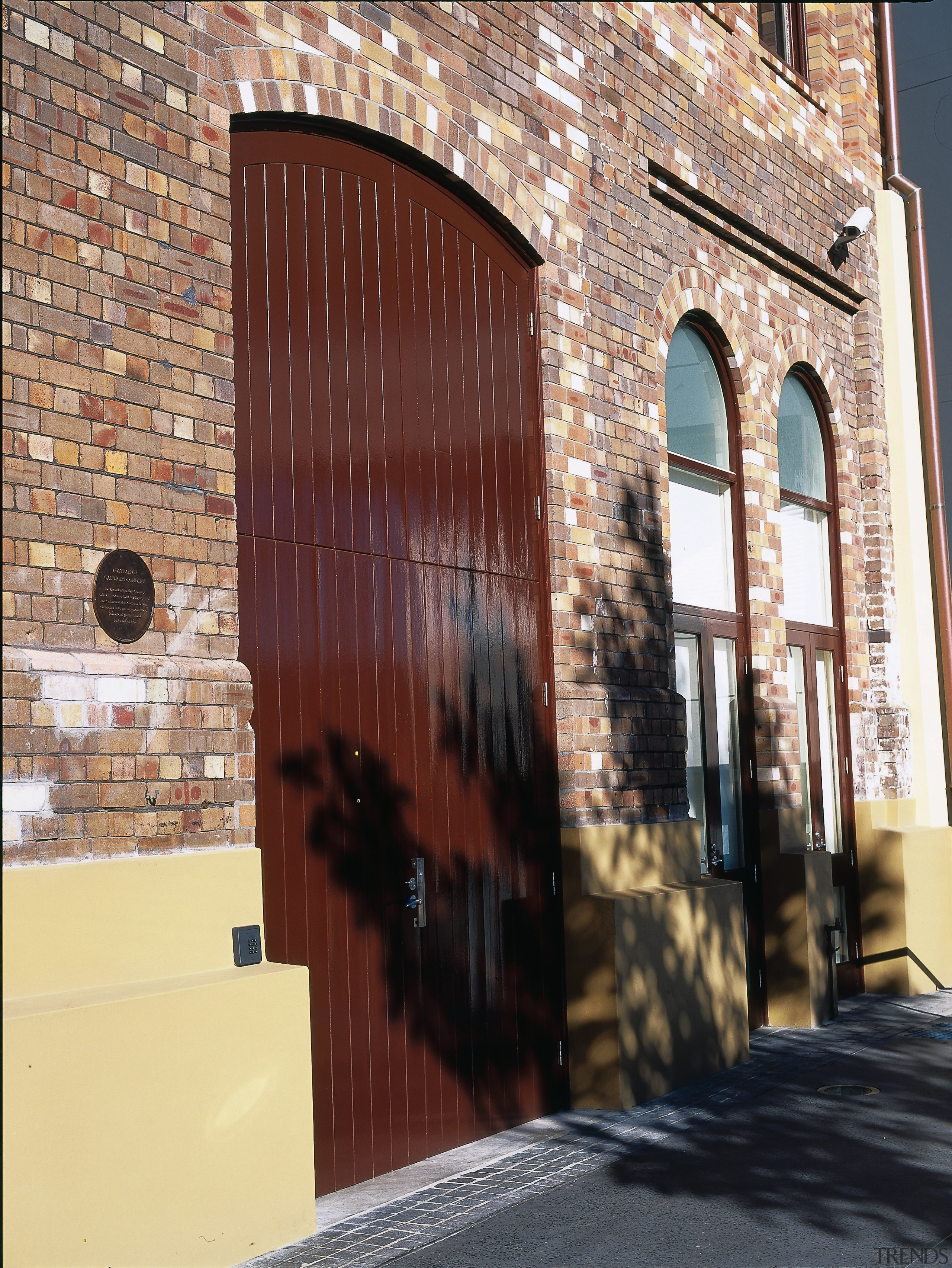 Brick heritage building with cream coloured base, and alley, arch, architecture, brick, brickwork, building, door, facade, wall, window