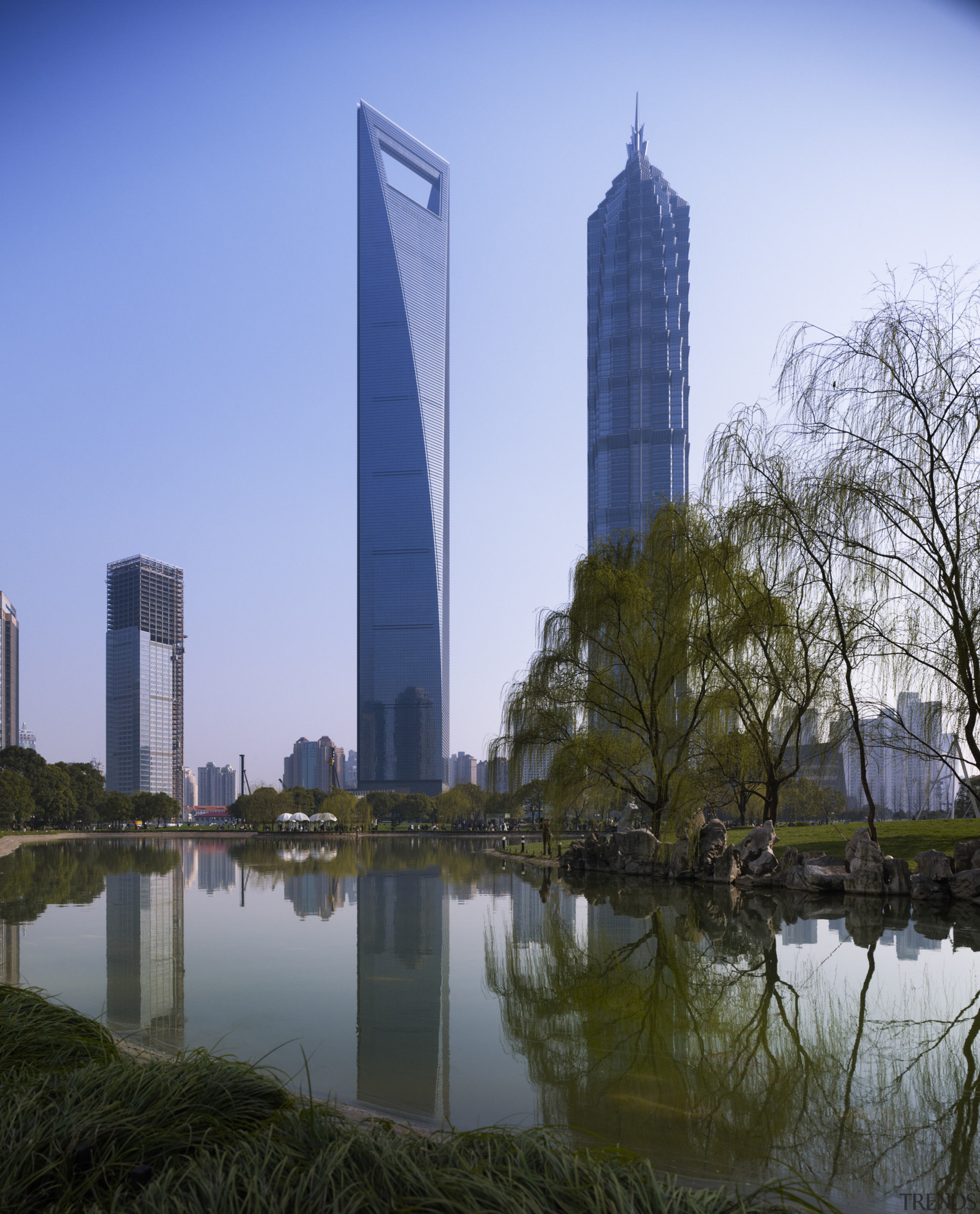 View of the Shanghai World Financial Centre in building, city, cityscape, condominium, corporate headquarters, daytime, landmark, metropolis, metropolitan area, reflection, sky, skyline, skyscraper, tower, tower block, tree, water, teal