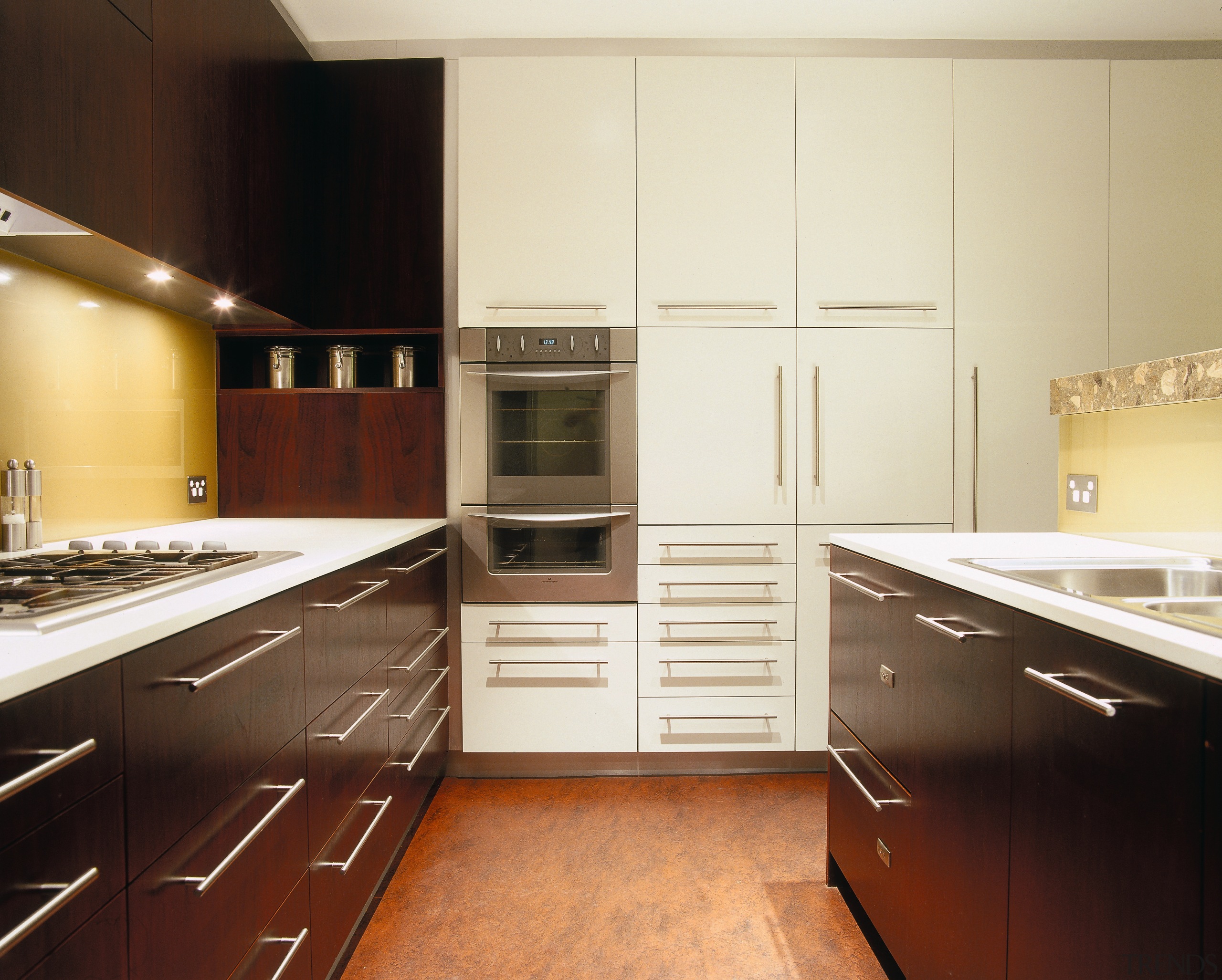 view of the kitchen showing dark stained american cabinetry, countertop, cuisine classique, floor, flooring, hardwood, interior design, kitchen, room, under cabinet lighting, wood flooring, yellow