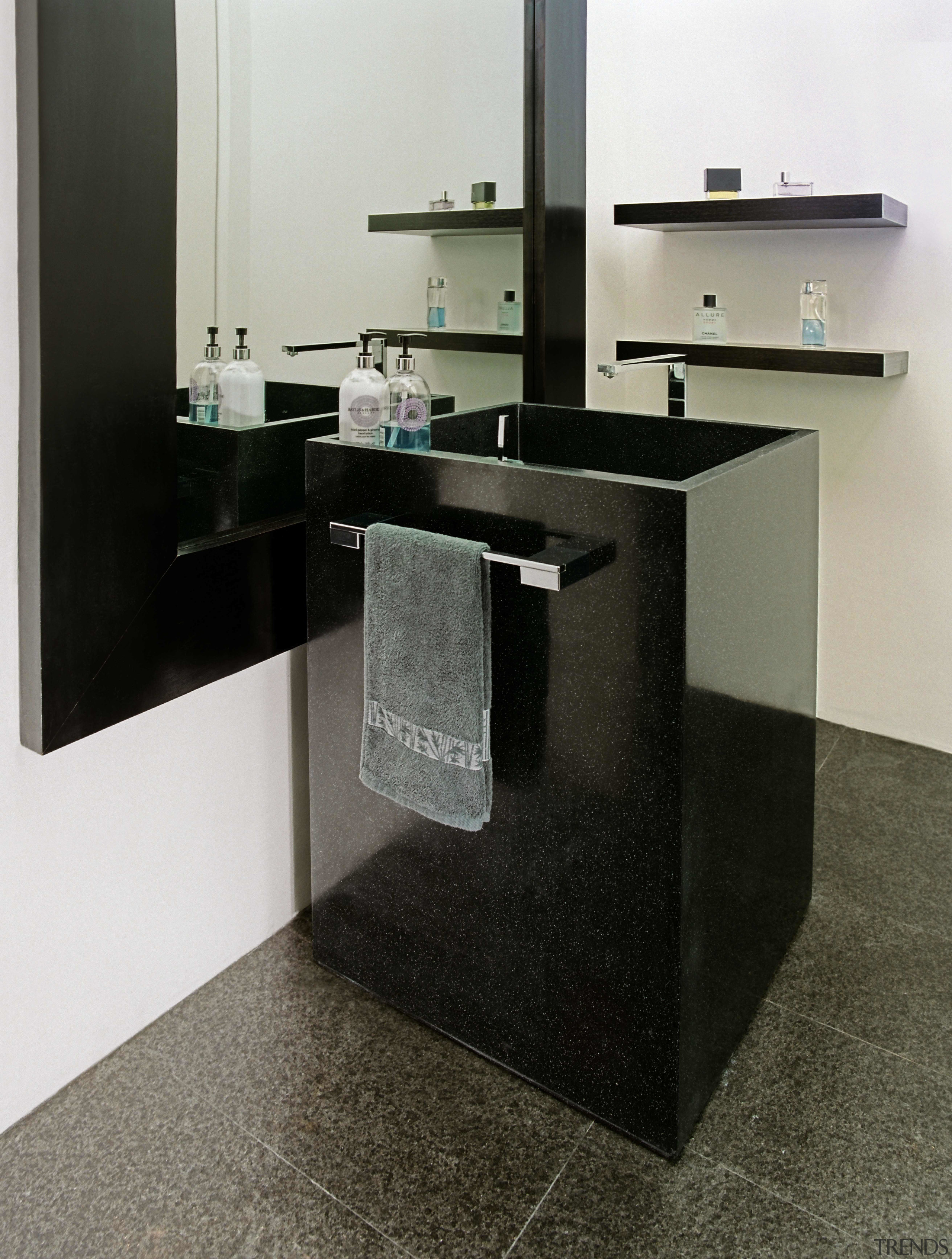 This powder room features a unique rectangular handbasin countertop, floor, flooring, furniture, product design, sink, table, tap, black, gray