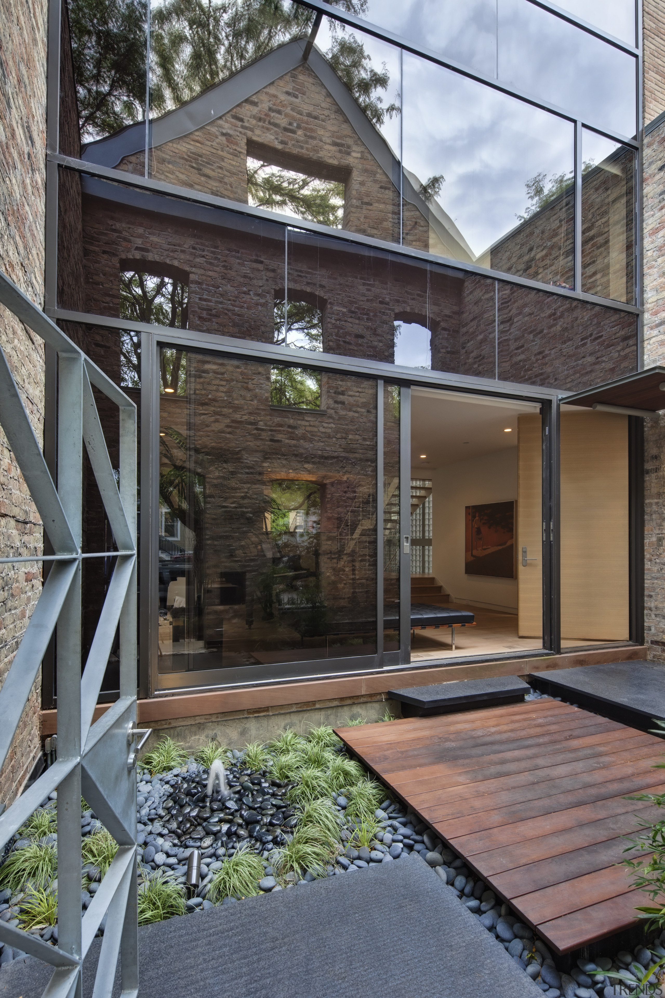 View of a renovated three-story home, built to architecture, backyard, courtyard, facade, home, house, outdoor structure, real estate, residential area, siding, yard, gray, black