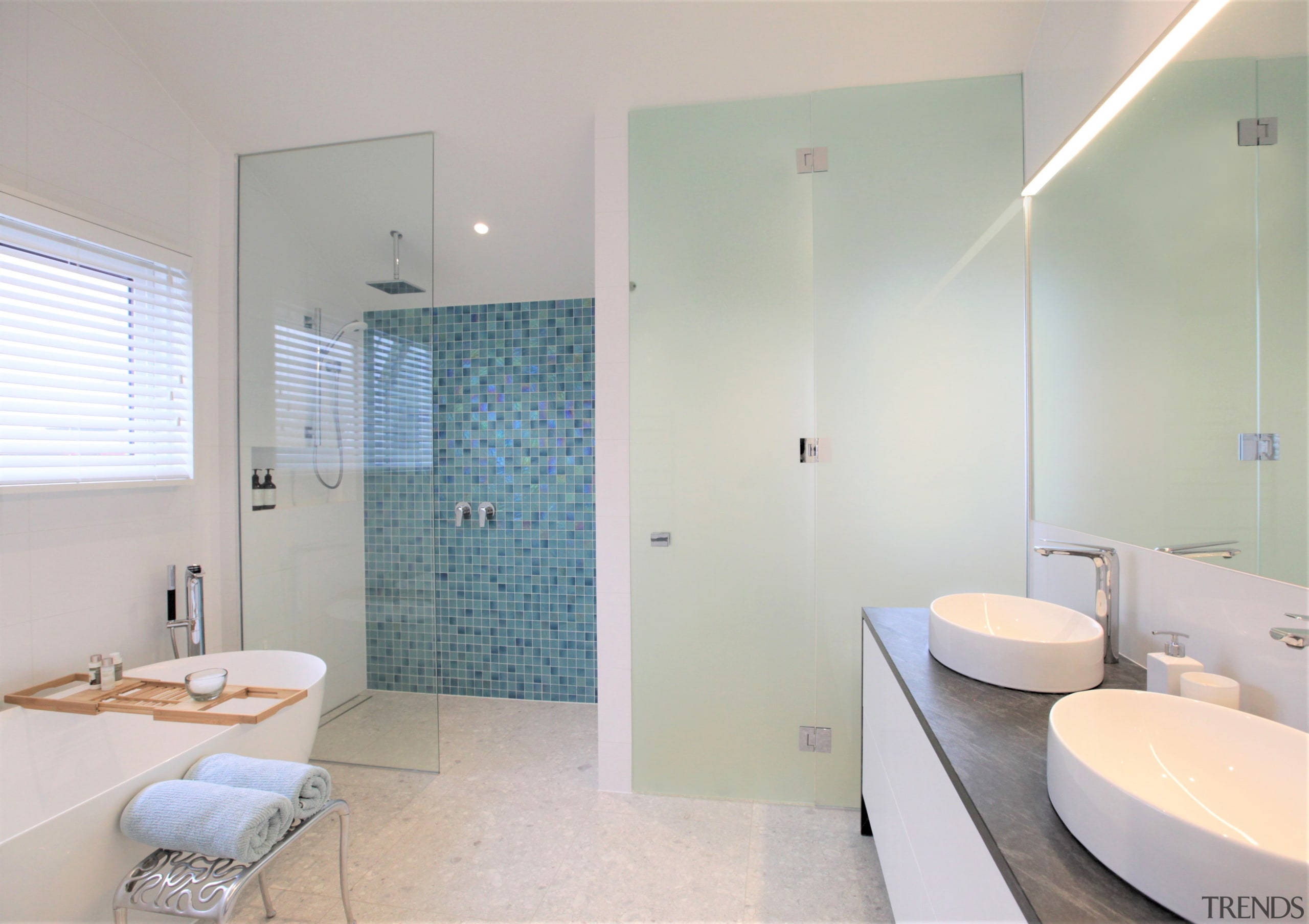 The home's seaside-themed material aesthetic includes aqua glass 