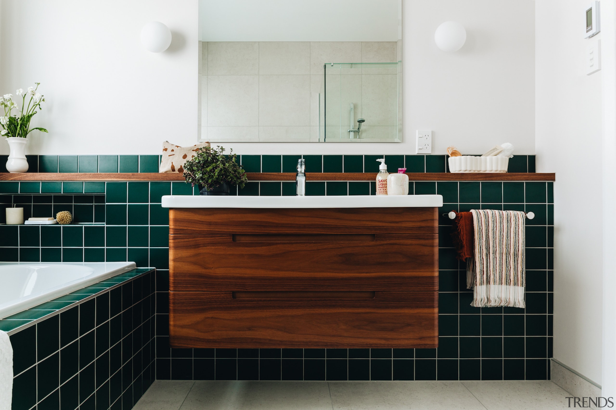 Evergreen tiles and a walnut-clad cantilevered vanity make 