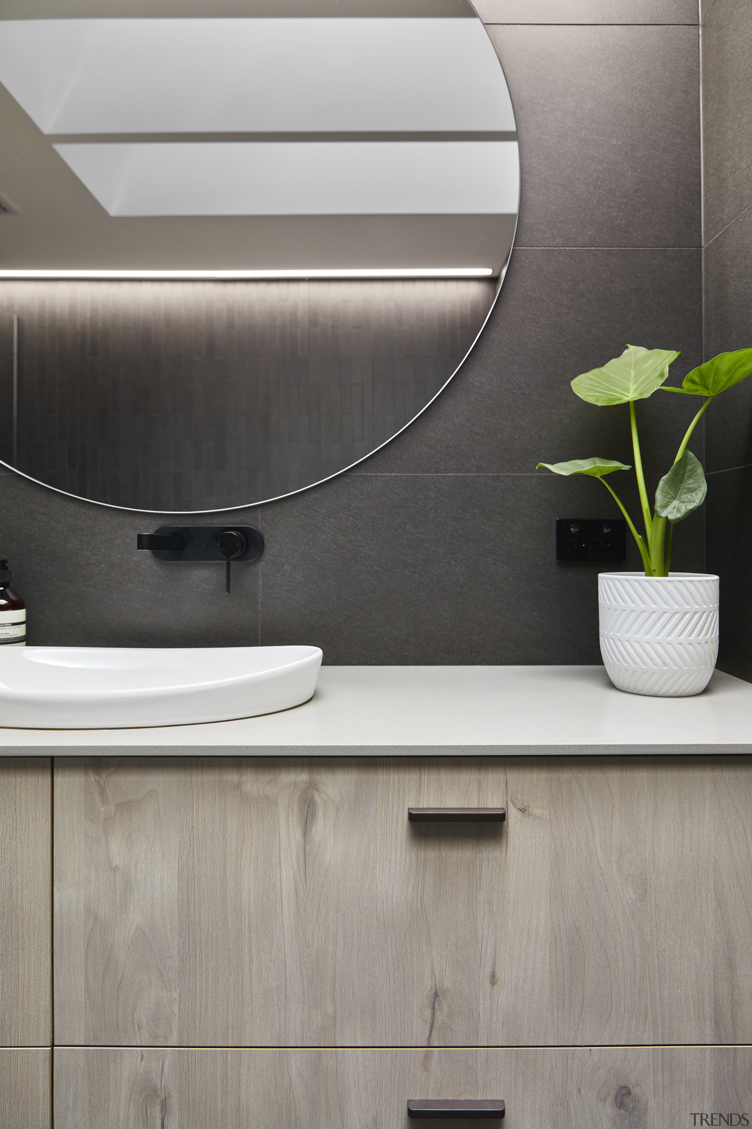 The custom designed oak vanity adds a natural element and warmth to the dramatic 