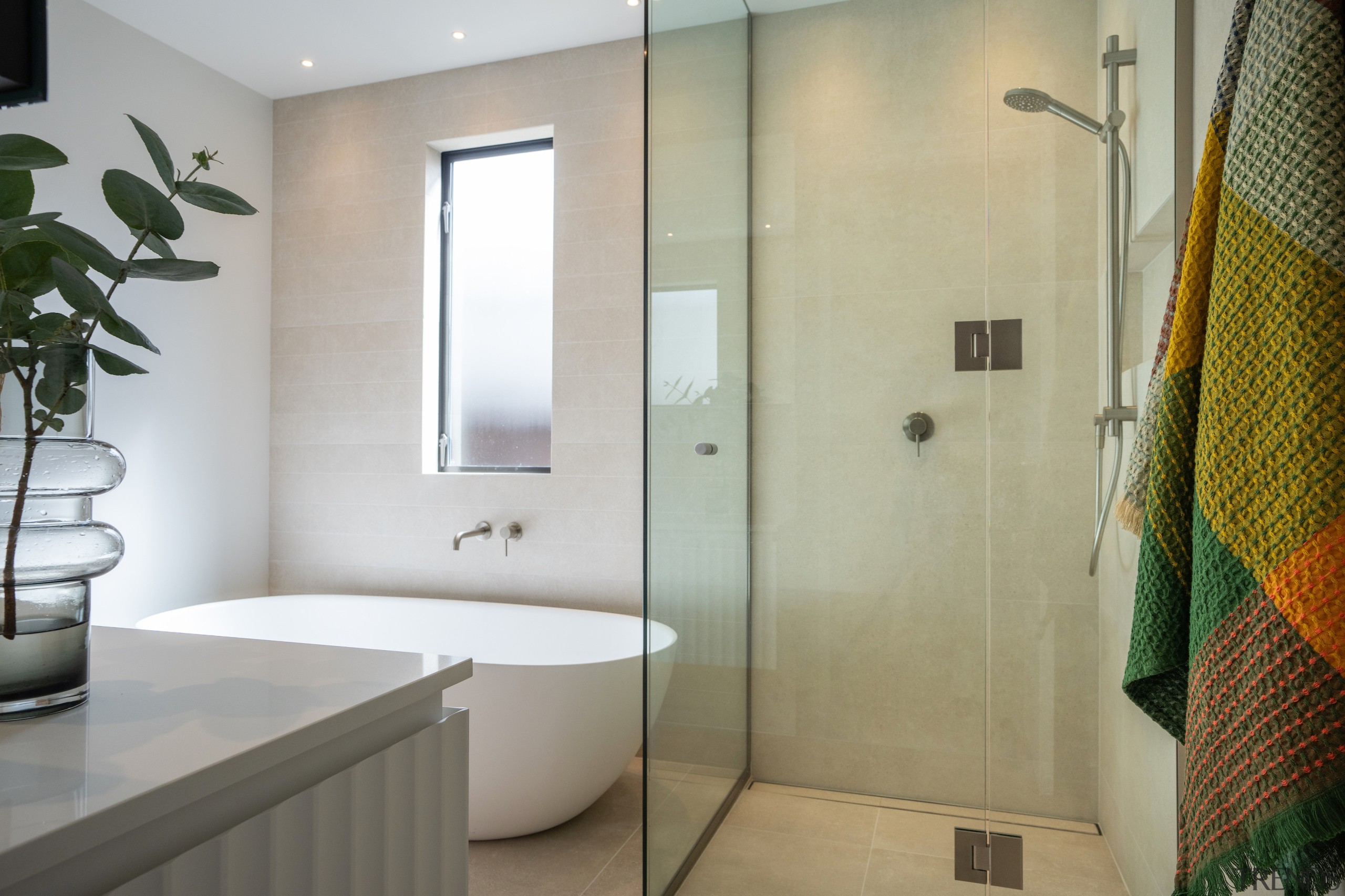 A glass-walled, walk-in shower enclosure enhances the sense 