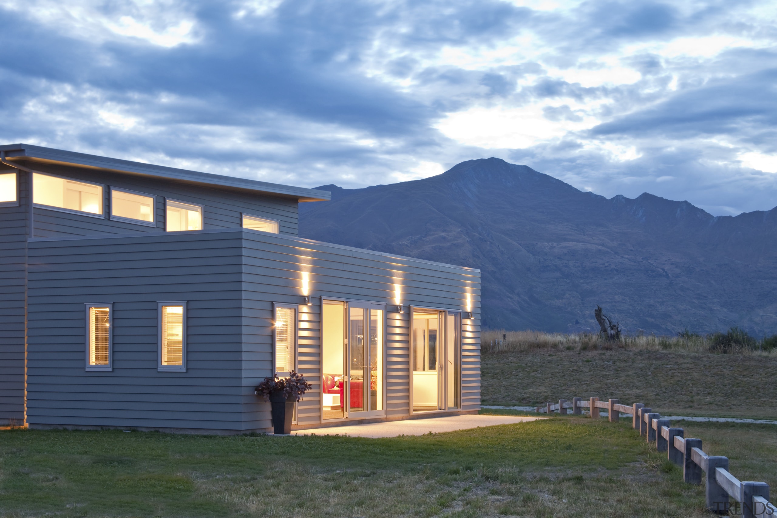 rear of house lit at dusk - rear cottage, elevation, facade, farmhouse, home, house, landscape, log cabin, property, real estate, siding, sky, teal, blue