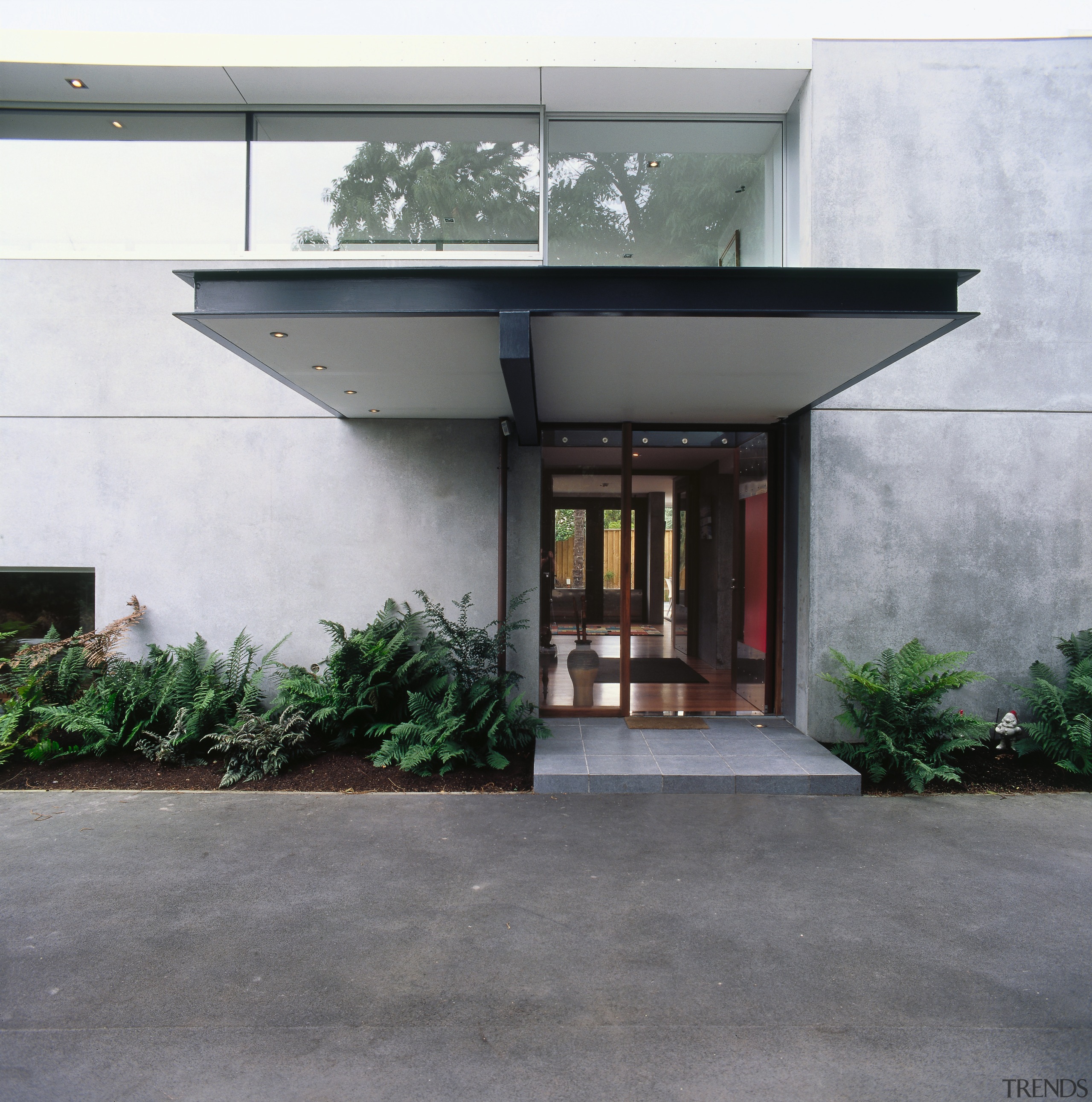 Exterior view of this contemporary home featuring thermomass architecture, facade, house, gray, white