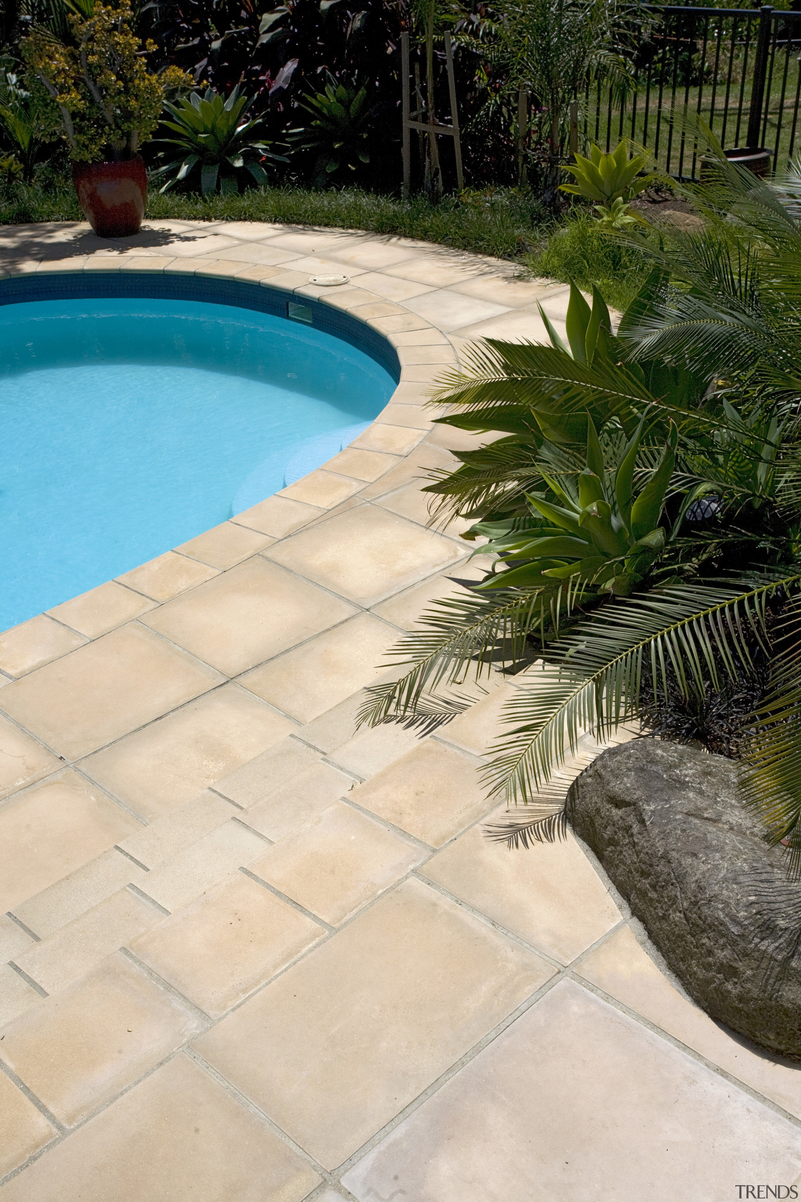 View of a pool with paving that features backyard, flagstone, floor, landscaping, outdoor structure, road surface, swimming pool, walkway, yard, orange