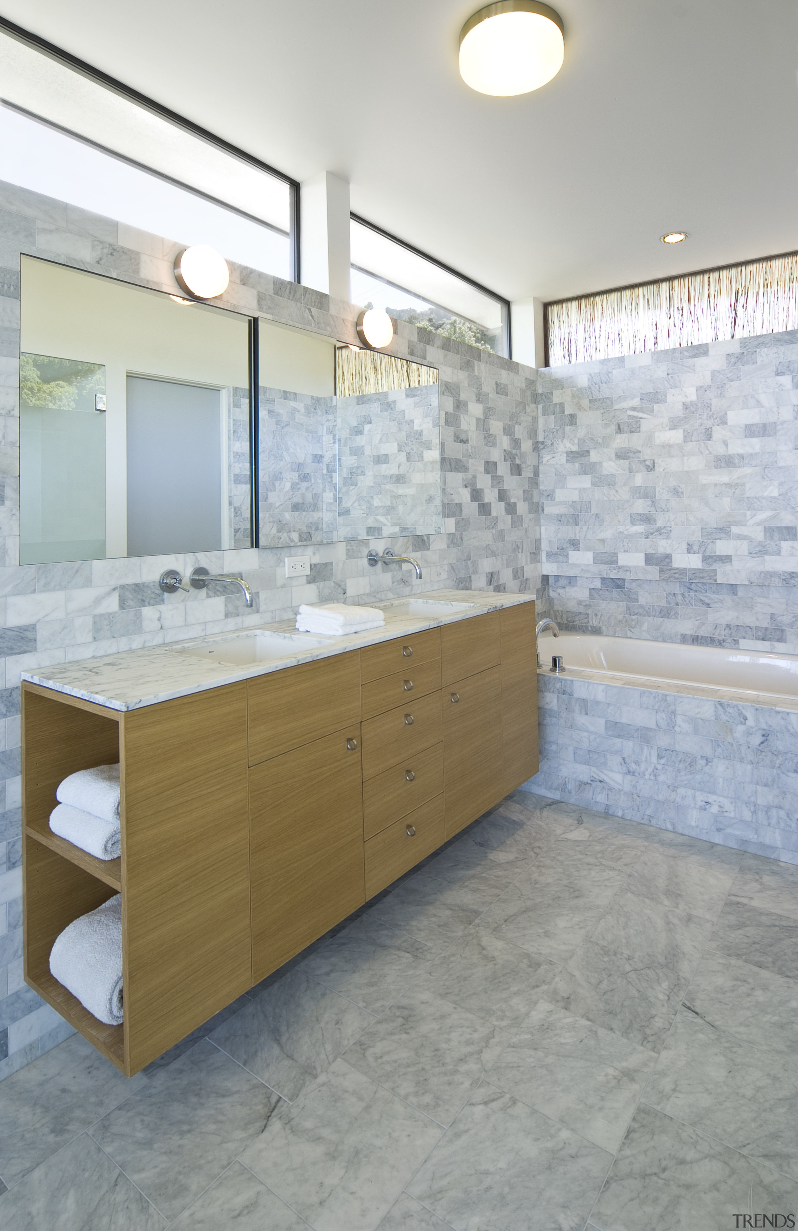 View of a bathroom which features a marble bathroom, bathroom cabinet, countertop, floor, flooring, home, interior design, room, sink, tile, gray