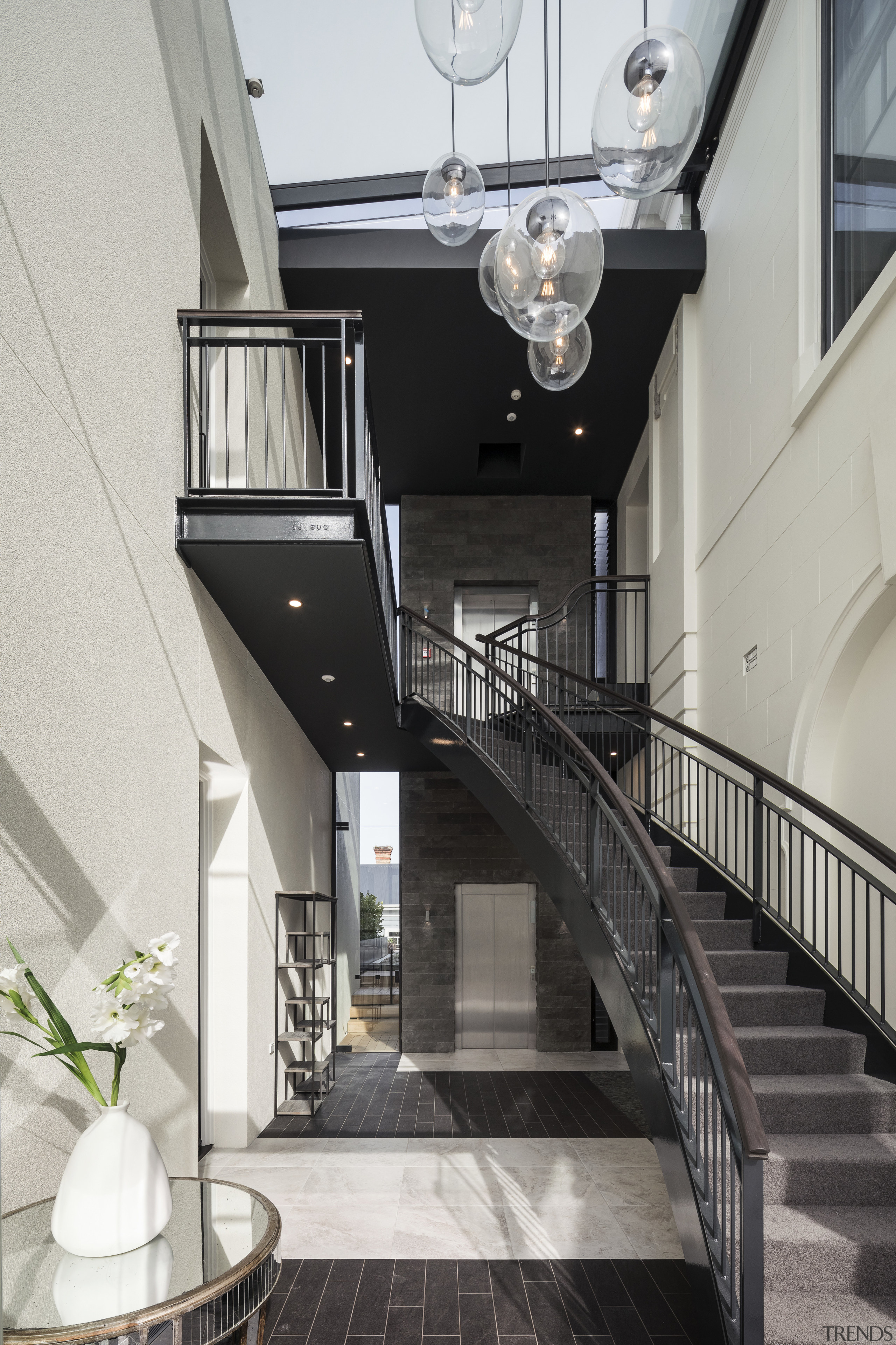 A curving steel stair and lift were installed apartment, architecture, building, daylighting, handrail, home, house, interior design, stairs, gray, black