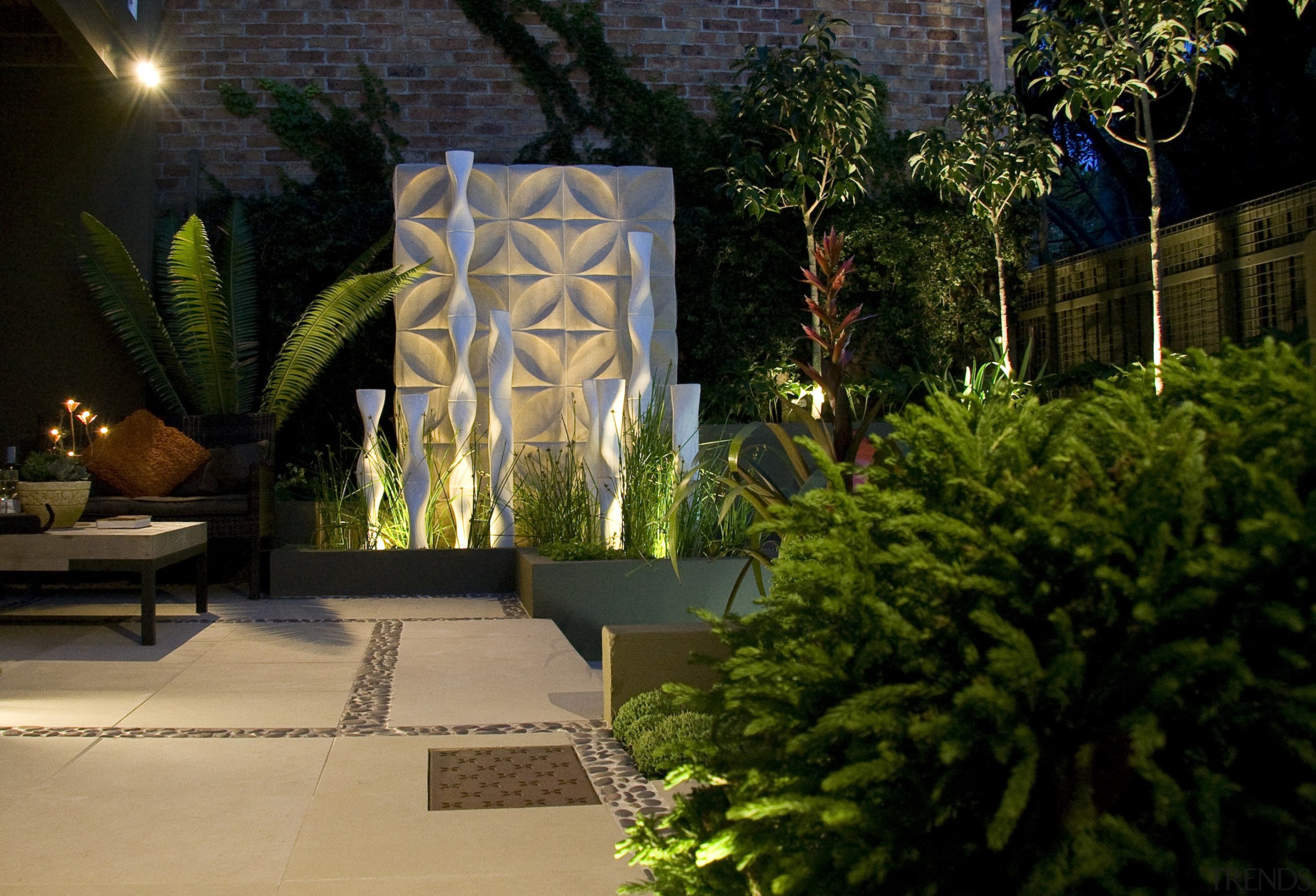 View of outdoor living area and courtyard featuring architecture, backyard, courtyard, estate, garden, home, landscape lighting, landscaping, lighting, majorelle blue, outdoor structure, plant, black, brown