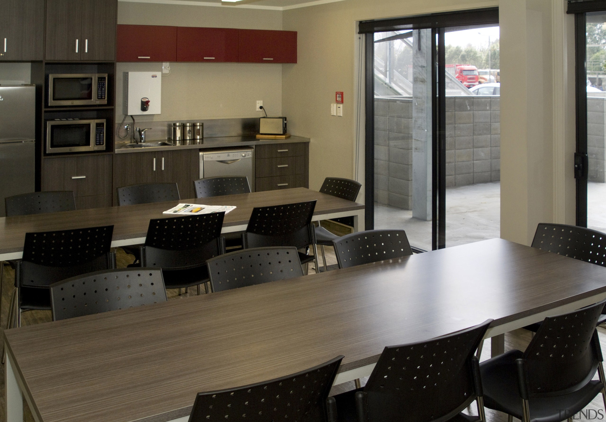 Interior view of the staff kitchen lunchroom within furniture, interior design, office, table, black, brown