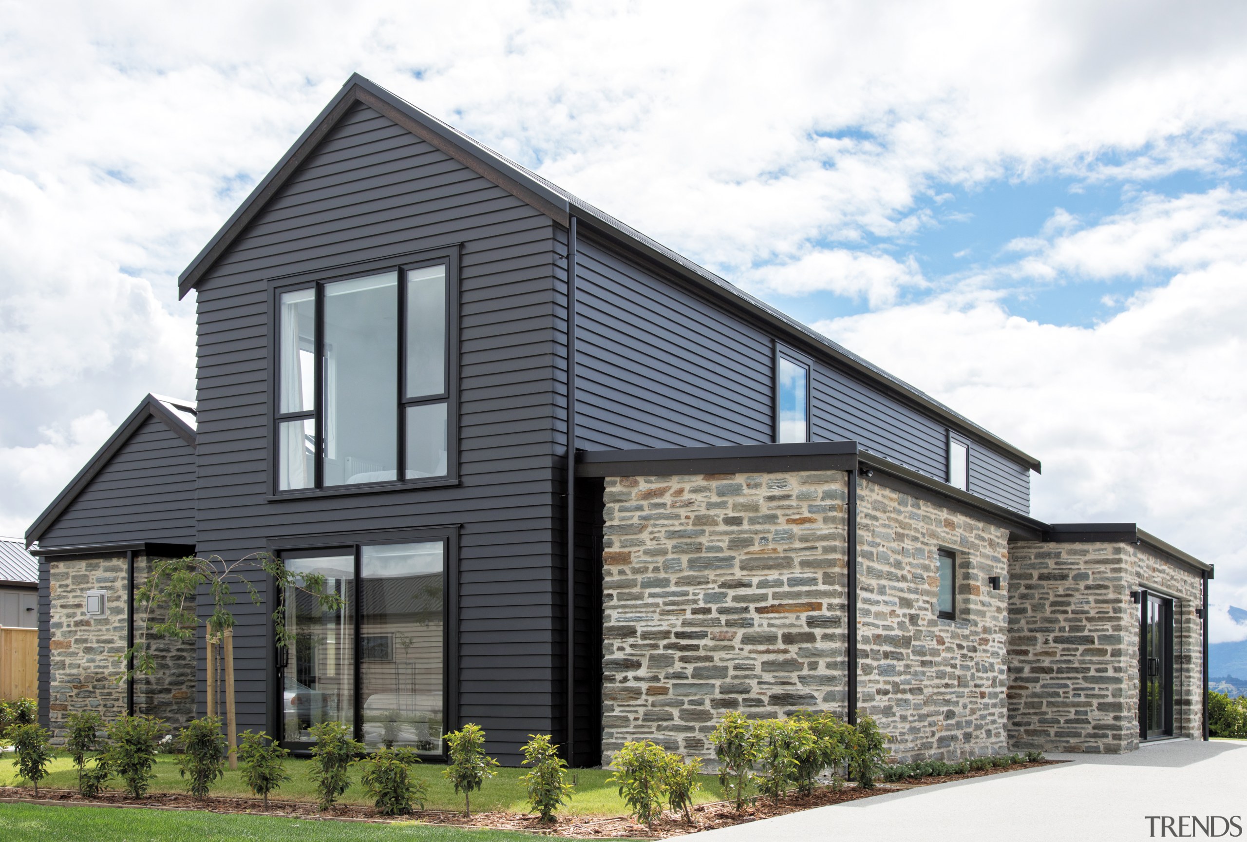 ​​​​​​​This GJ Gardner Wanaka showhome is clad in architecture, brick, building, cottage, facade, farmhouse, home, house, land lot, property, real estate, residential area, roof, siding, tree, white