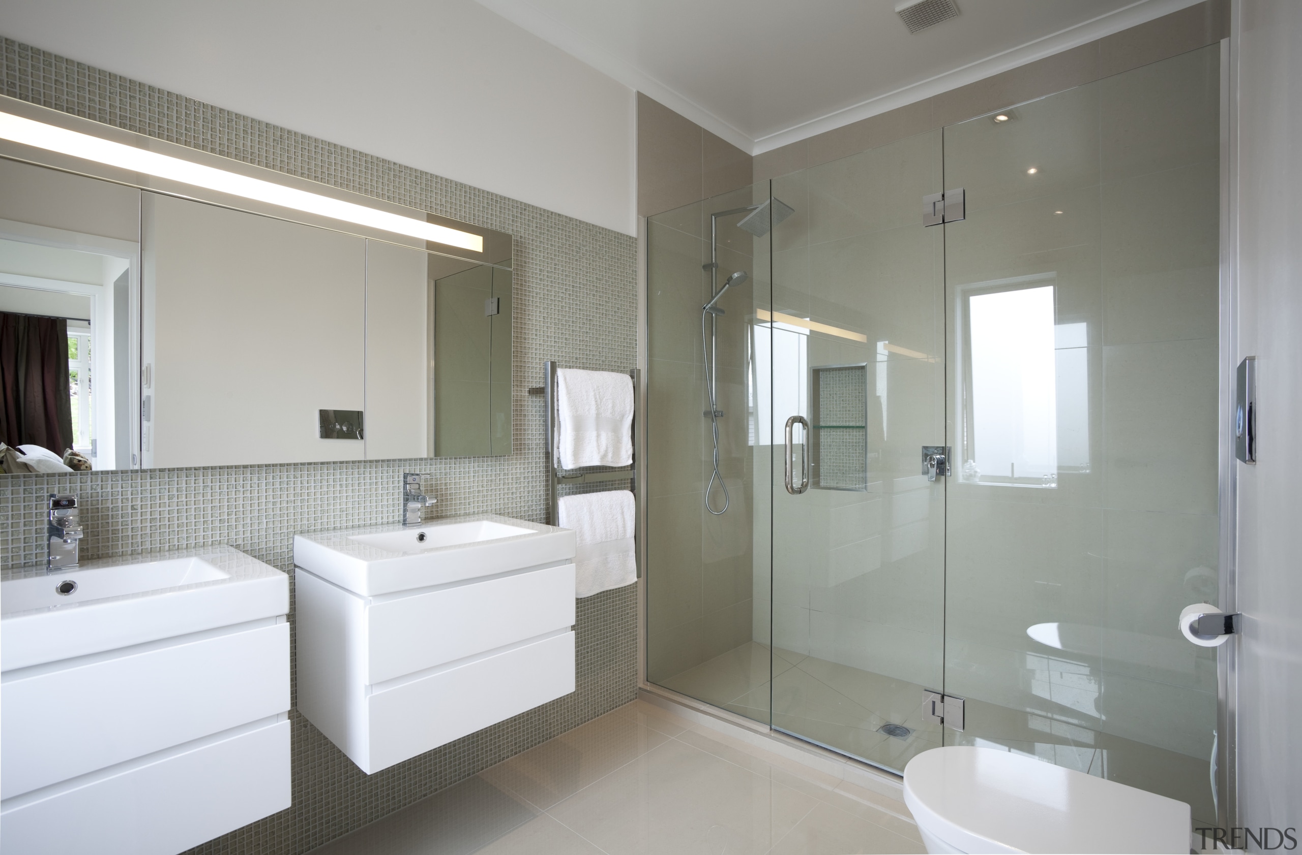 Bathroom with white vanities and glassed in shower. architecture, bathroom, bathroom accessory, bathroom cabinet, floor, home, interior design, real estate, room, window, gray