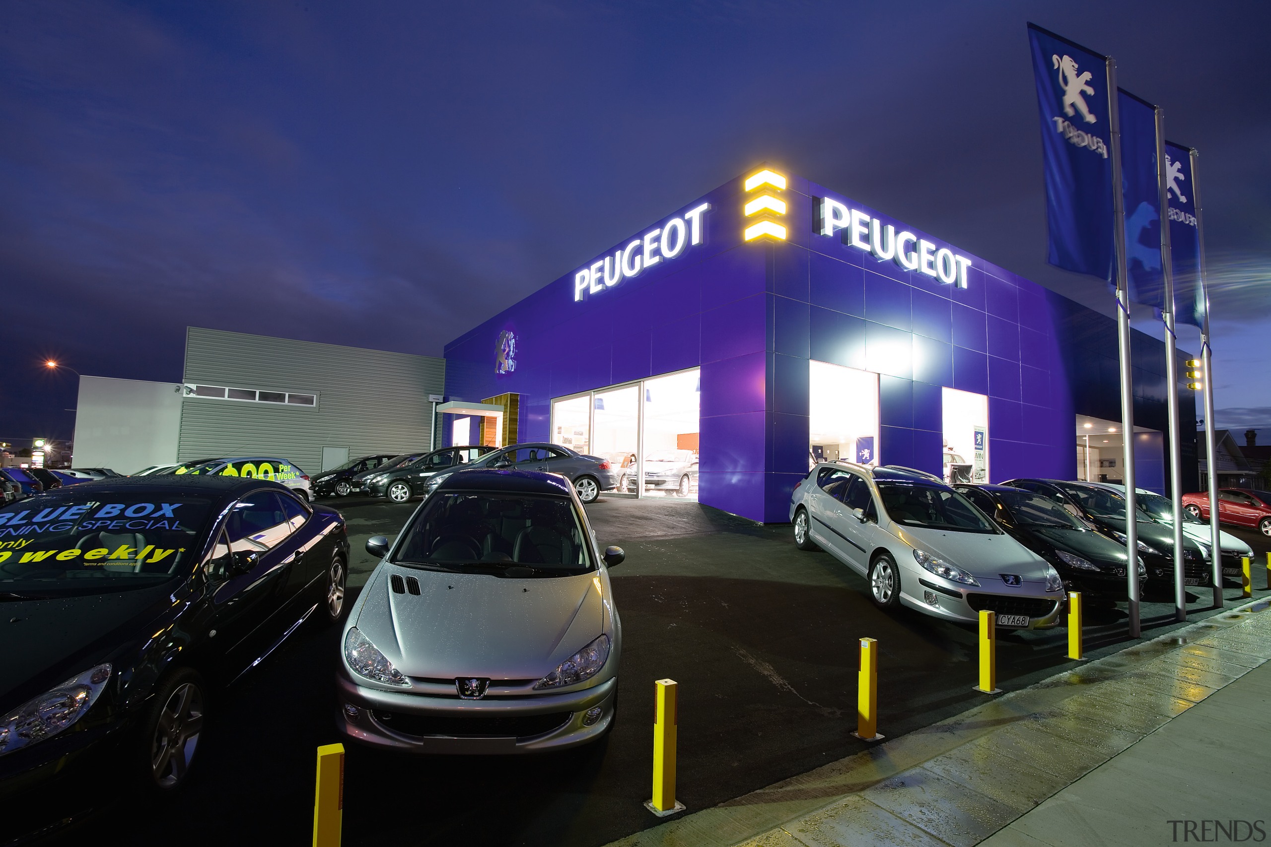 A view of the Puergot showroom. - A auto show, automotive design, building, car, car dealership, family car, luxury vehicle, mid size car, motor vehicle, night, sky, sport utility vehicle, technology, vehicle, blue