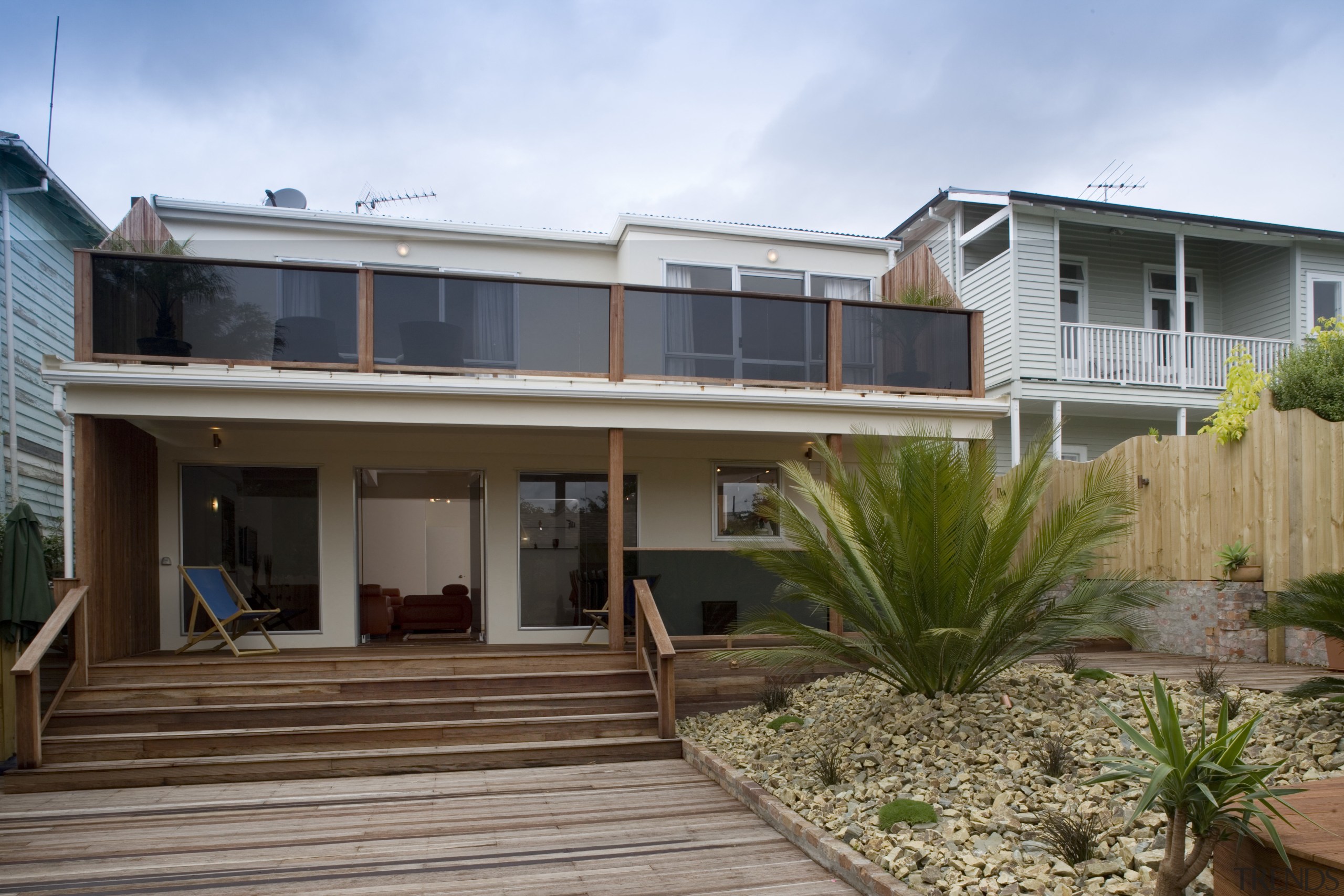 A view of a home renovated by Logic architecture, backyard, cottage, deck, elevation, estate, facade, home, house, outdoor structure, property, real estate, residential area, roof, siding, window, brown