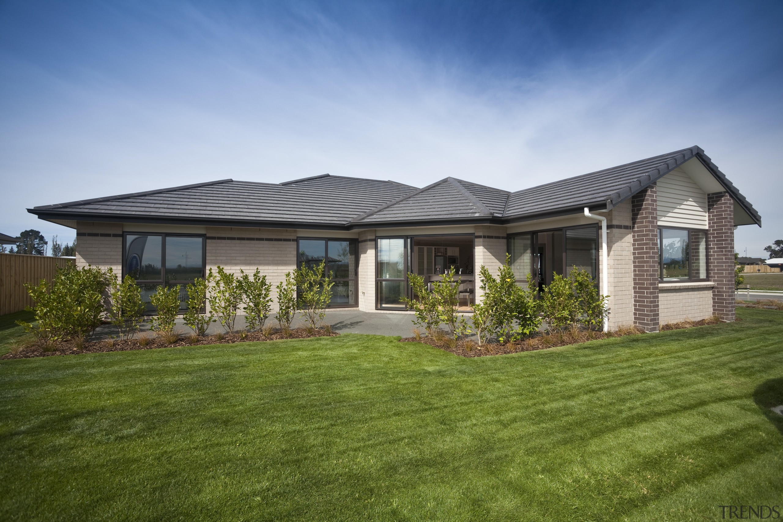 View of Platinum Homes show home with solid backyard, cottage, elevation, estate, facade, farmhouse, grass, home, house, land lot, landscape, lawn, property, real estate, residential area, roof, siding, sky, suburb, yard, brown, teal