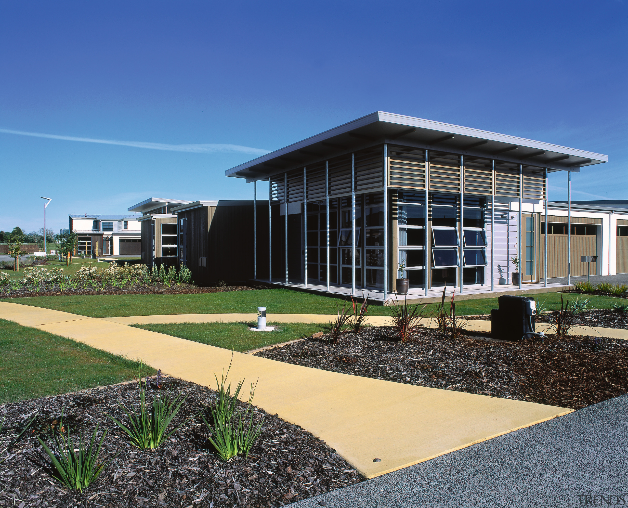 An exterior view of the retirement village. - architecture, building, campus, corporate headquarters, estate, facade, grass, home, house, property, real estate, residential area, sky, blue, black