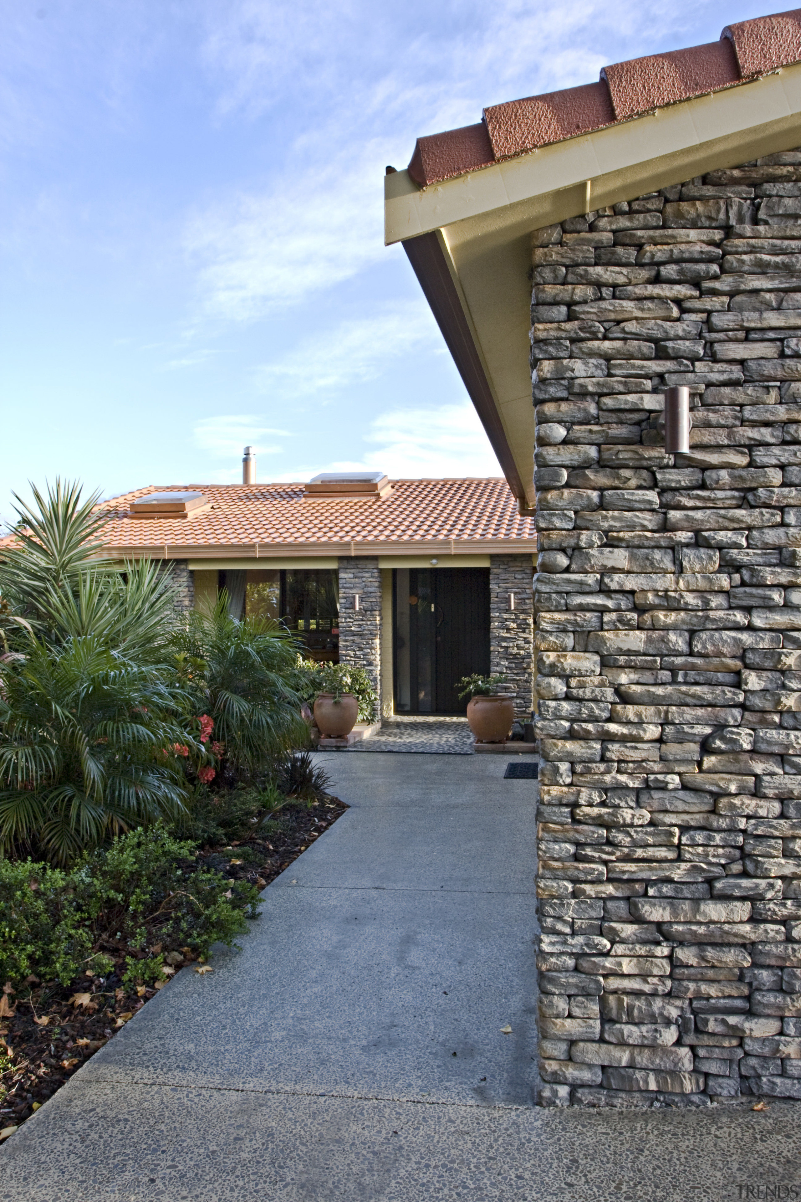 Exterior view of a renovated home which features brick, cottage, estate, facade, hacienda, home, house, outdoor structure, property, real estate, residential area, roof, siding, sky, villa, walkway, wall, teal, gray