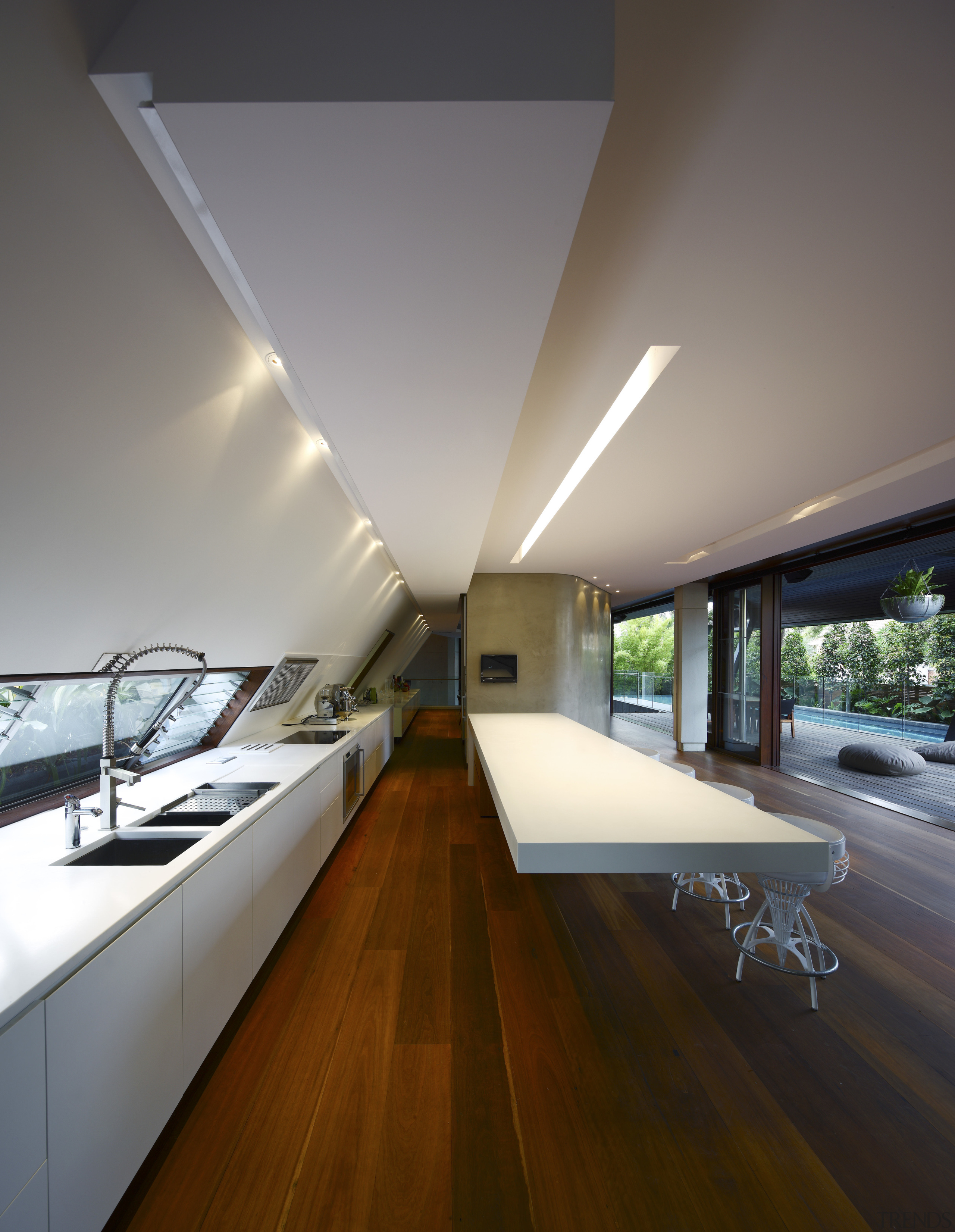 View of kitchen area featuring hardwood flooring, island apartment, architecture, ceiling, daylighting, house, interior design, gray