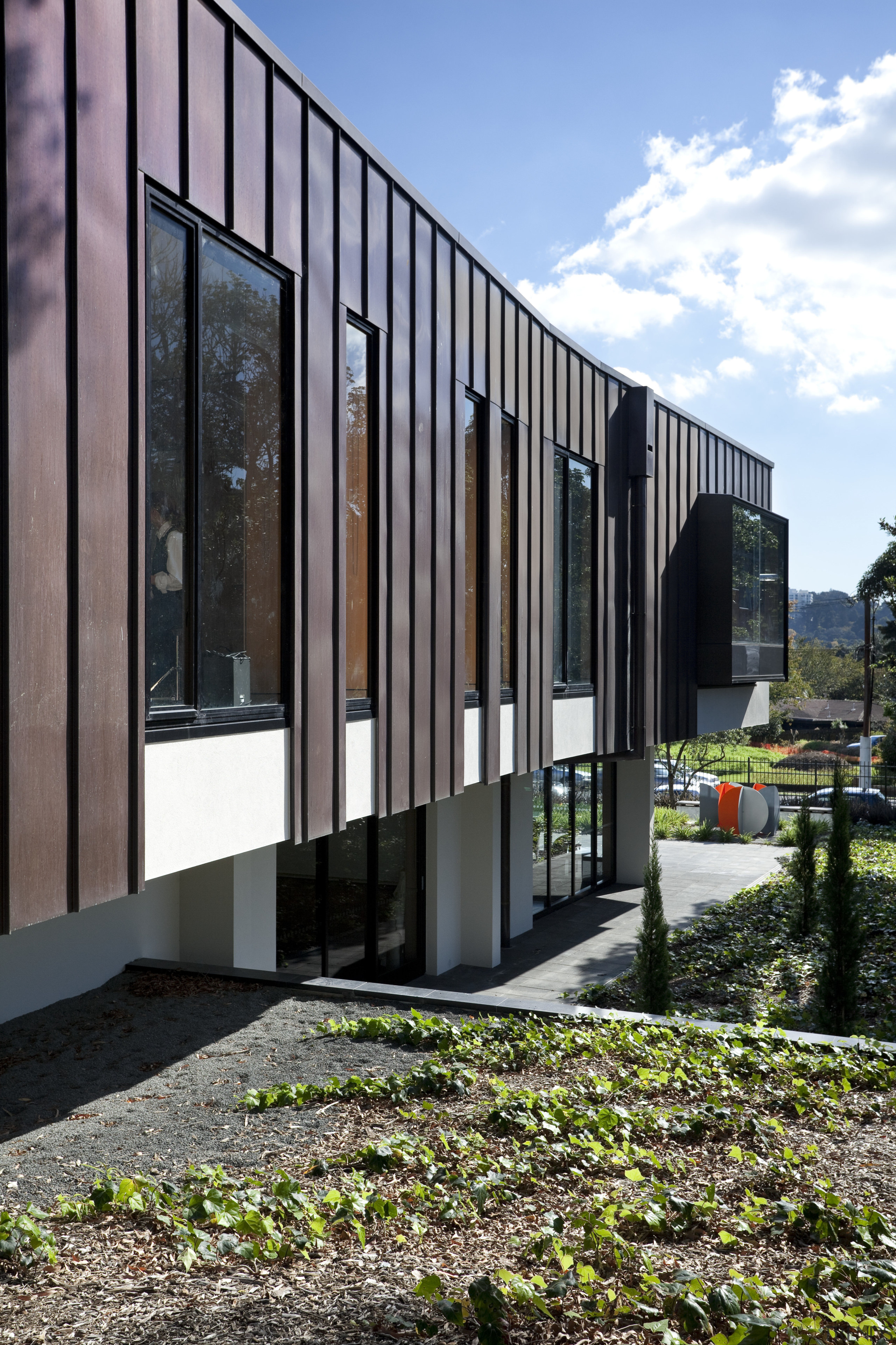 Exterior with red cladding and garden. - Exterior architecture, building, corporate headquarters, facade, home, house, real estate, residential area, black, gray