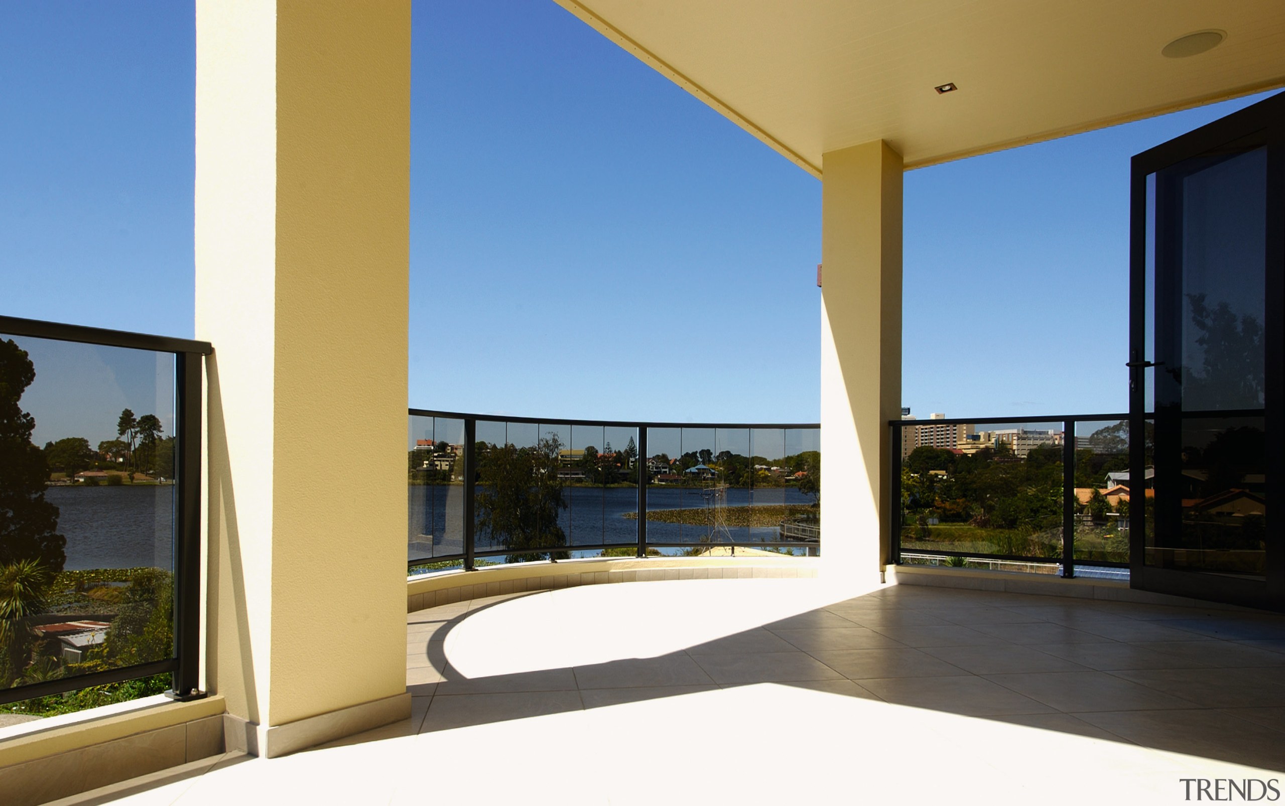 Large balcony with curved tinted glass balustrade. apartment, condominium, daylighting, door, estate, home, house, interior design, property, real estate, sky, window, teal