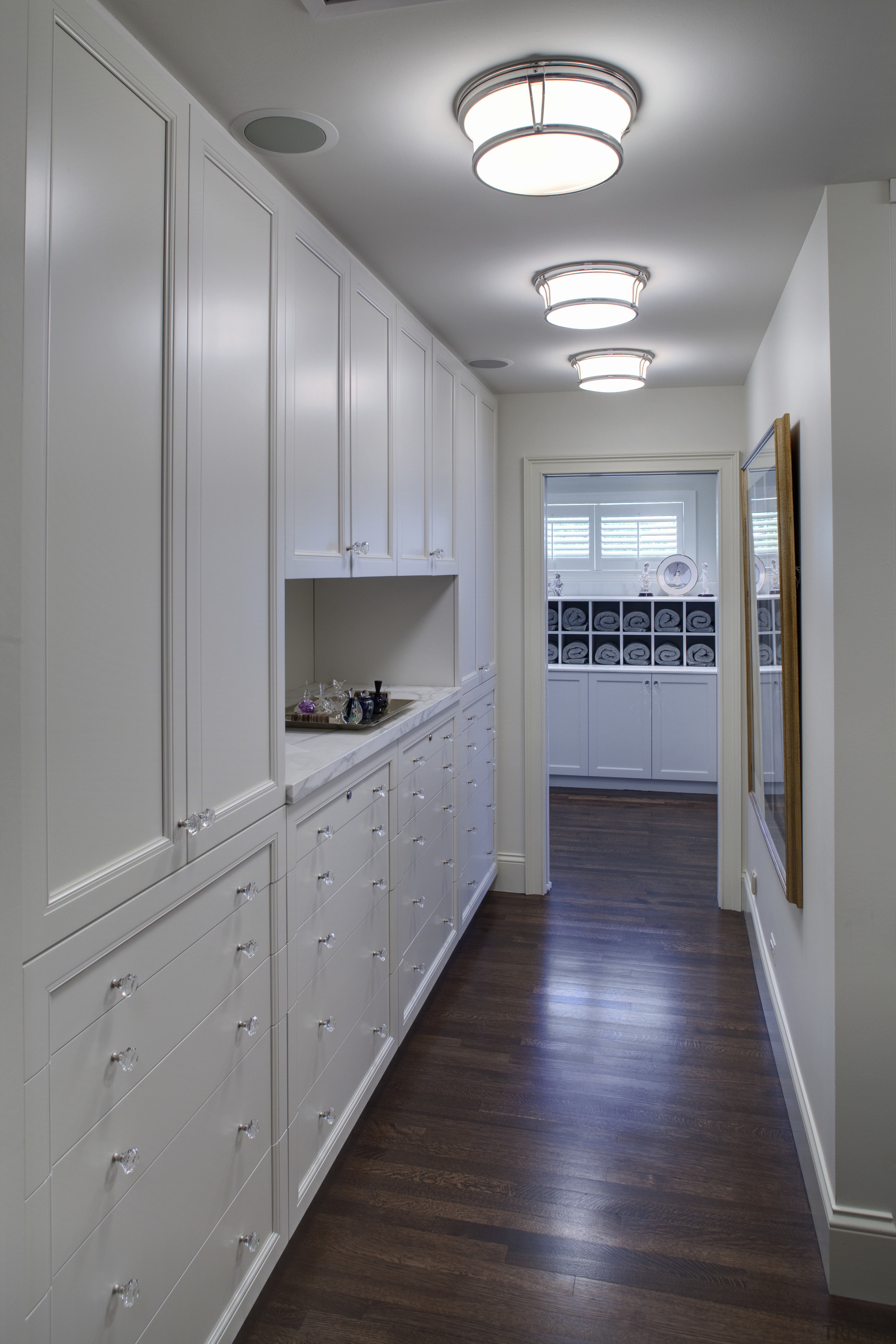 View of a hallway with dark-stained wooden flooring, cabinetry, countertop, floor, flooring, interior design, kitchen, room, gray