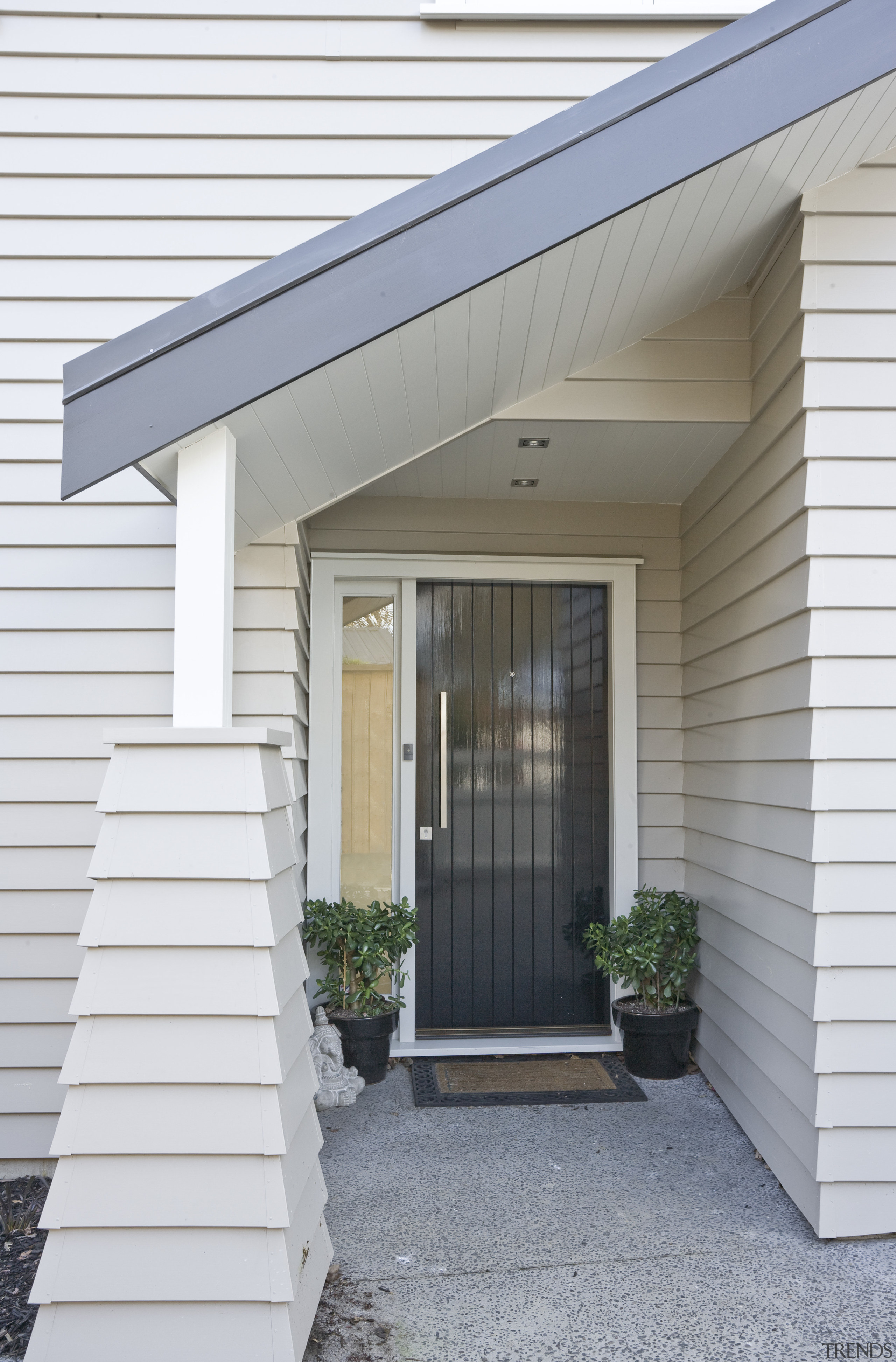 Exterior view of a new home designed by daylighting, door, facade, home, house, porch, property, real estate, residential area, siding, window, white, gray