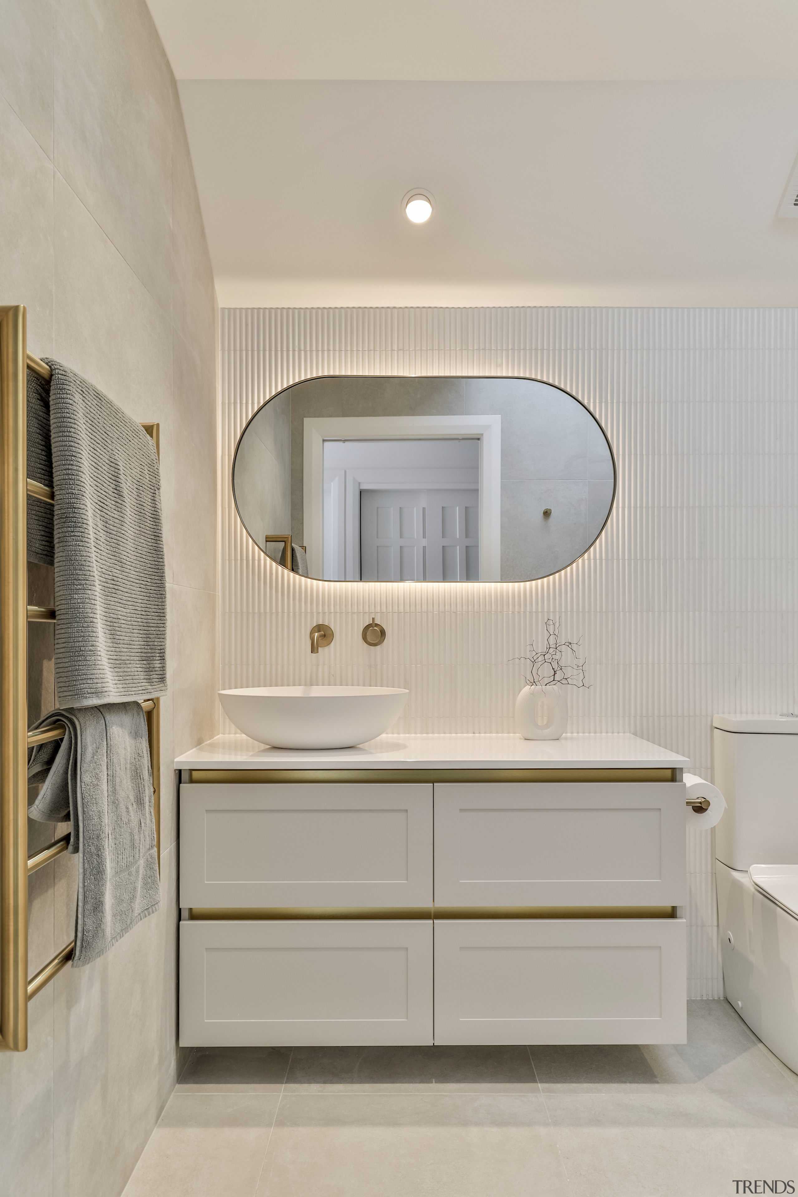 A refined custom back-lit mirror with brass frame 