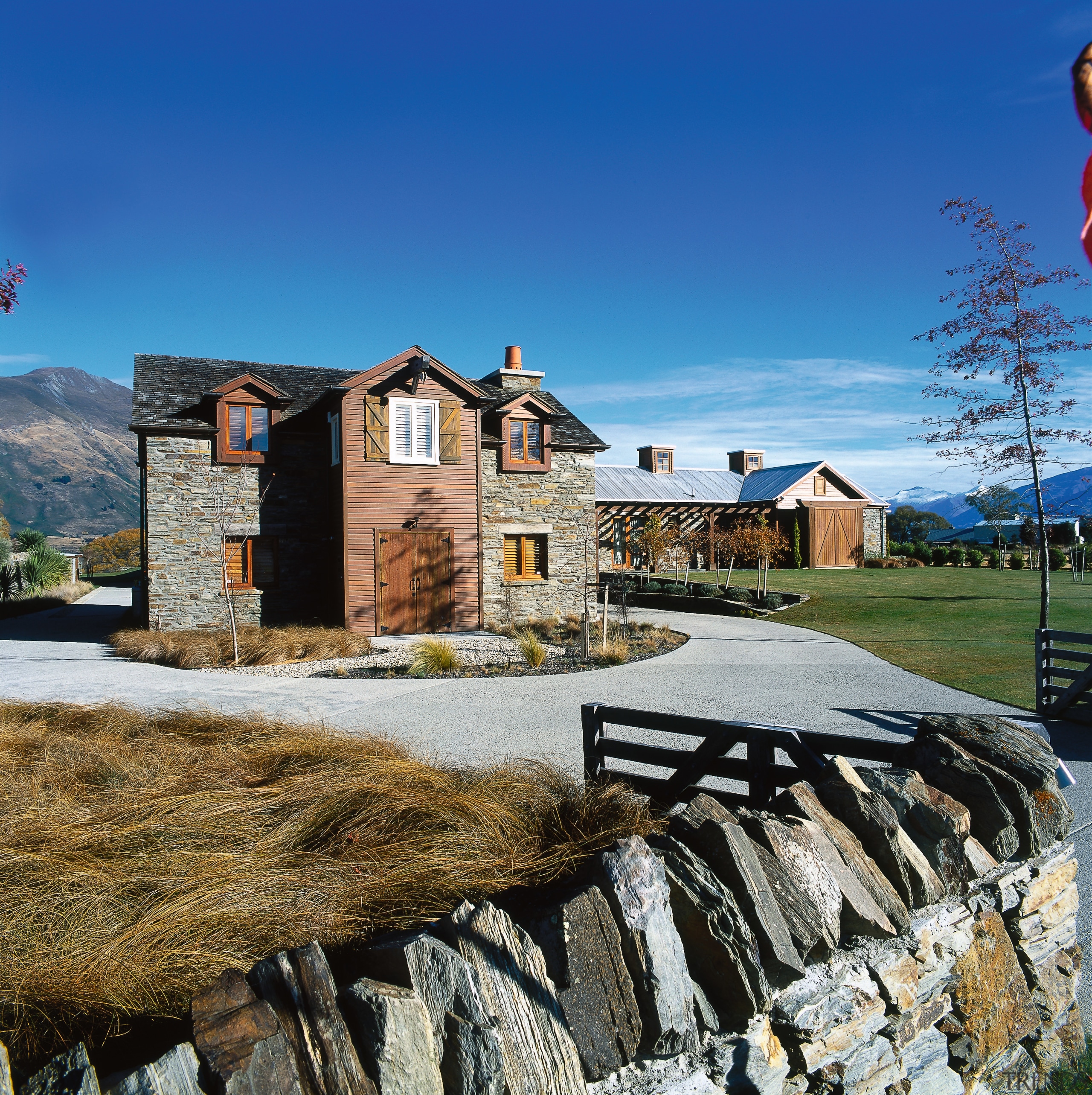 An exterior view of the home, grass, stone building, cloud, cottage, farmhouse, home, house, mountain, mountain range, property, real estate, residential area, sky, winter, blue