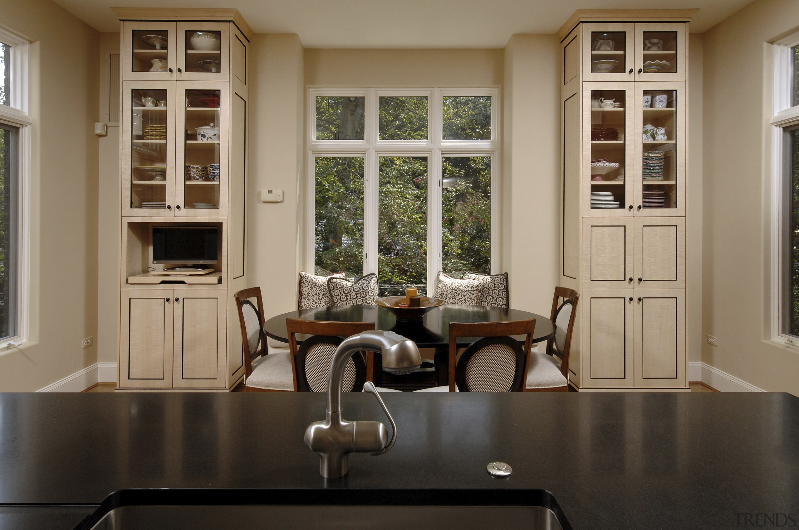 Designer Jennifer Gilmer, CKD, specified two islands for cabinetry, countertop, floor, flooring, furniture, home, interior design, kitchen, living room, room, table, window, brown, black